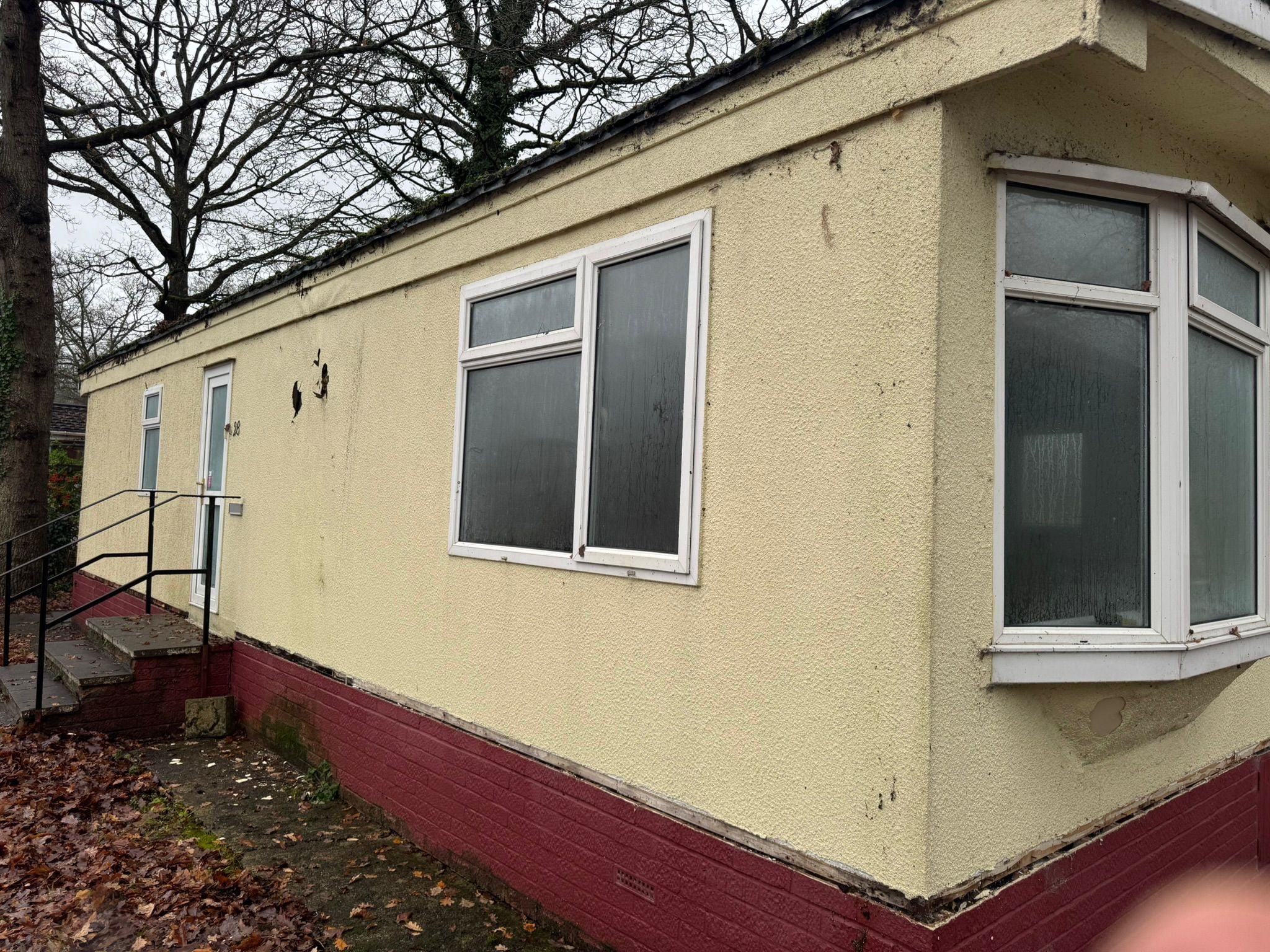 Park home exterior before renovation showing aged walls