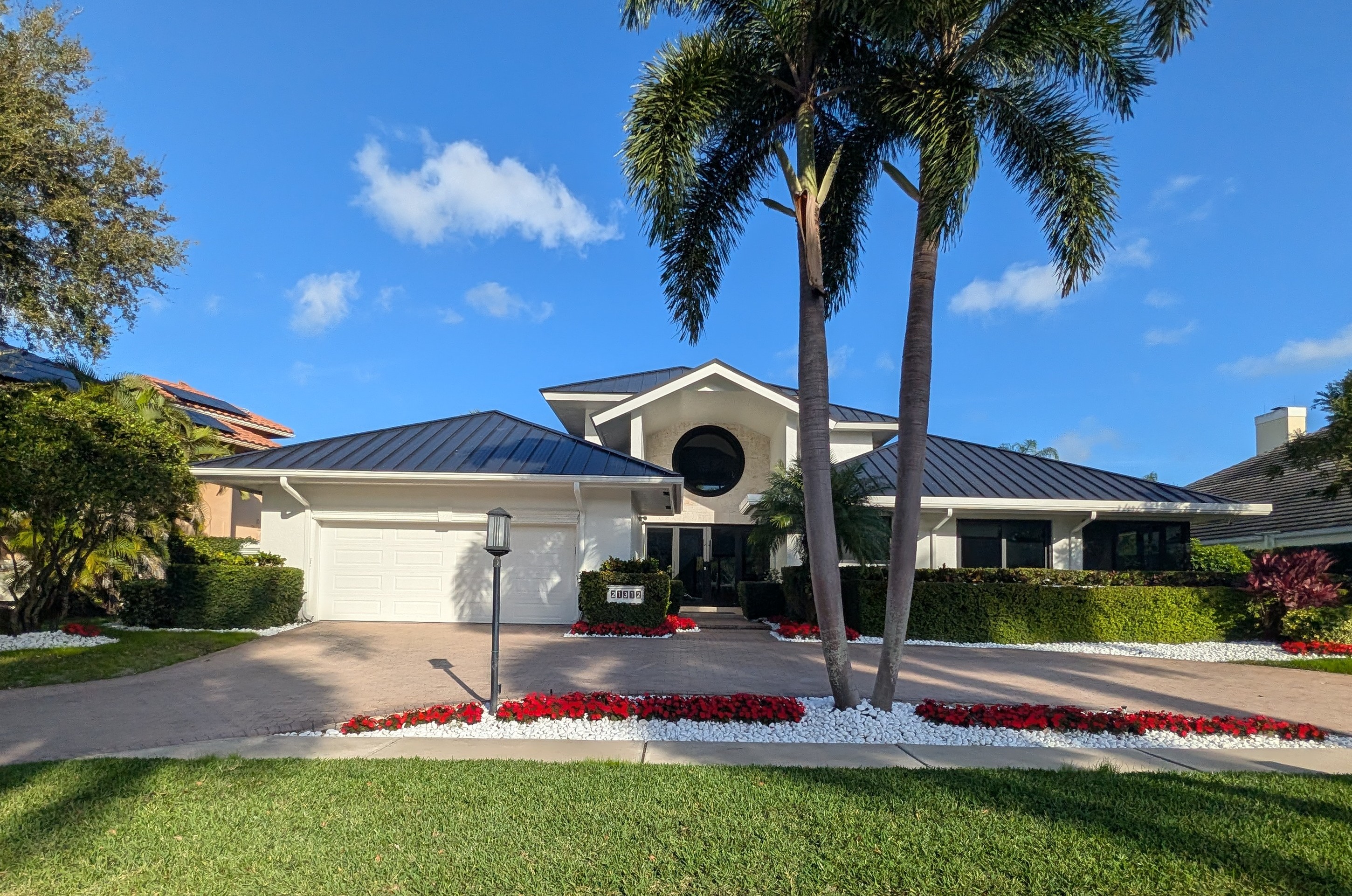 Front exterior with new metal roof, landscaping and palm trees