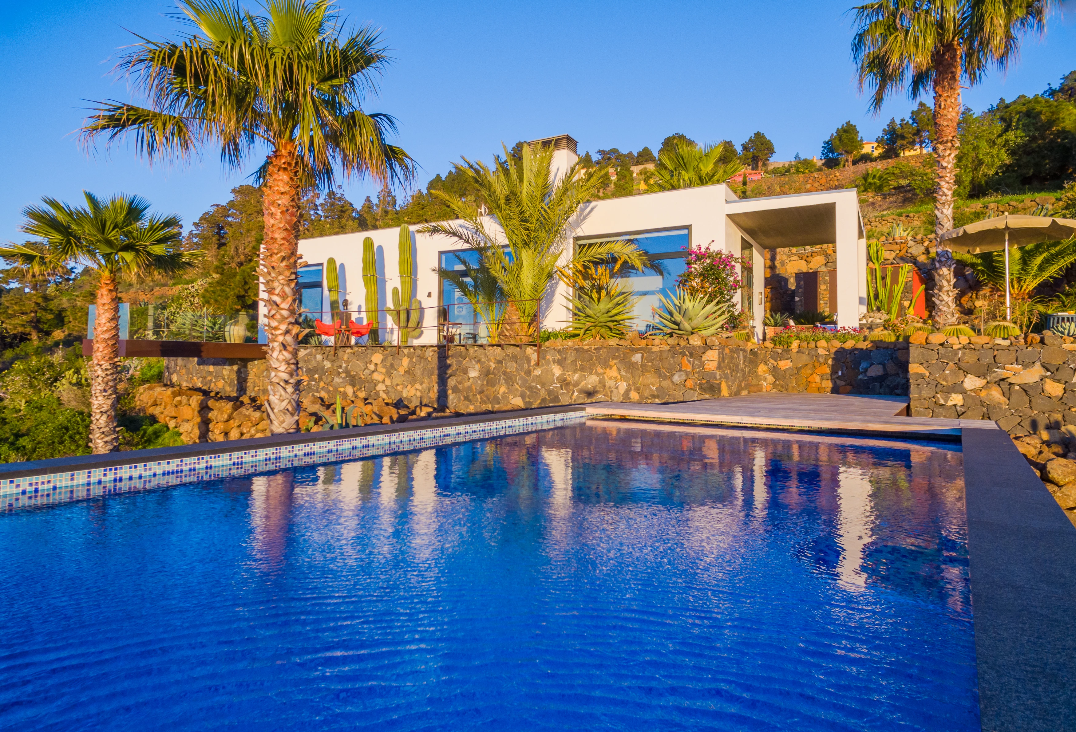 Villa exterior with lush tropical gardens and swimming pool