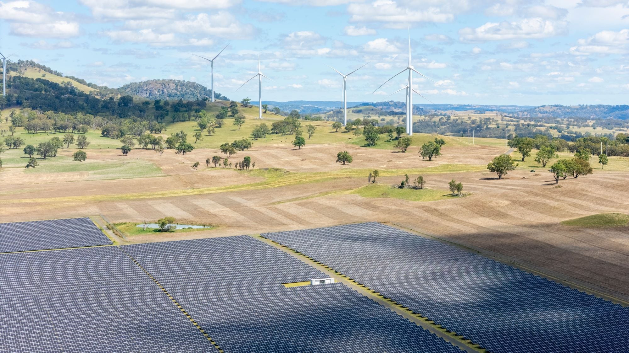 Wind turbines and solar panels in Australian rural landscape representing renewable energy