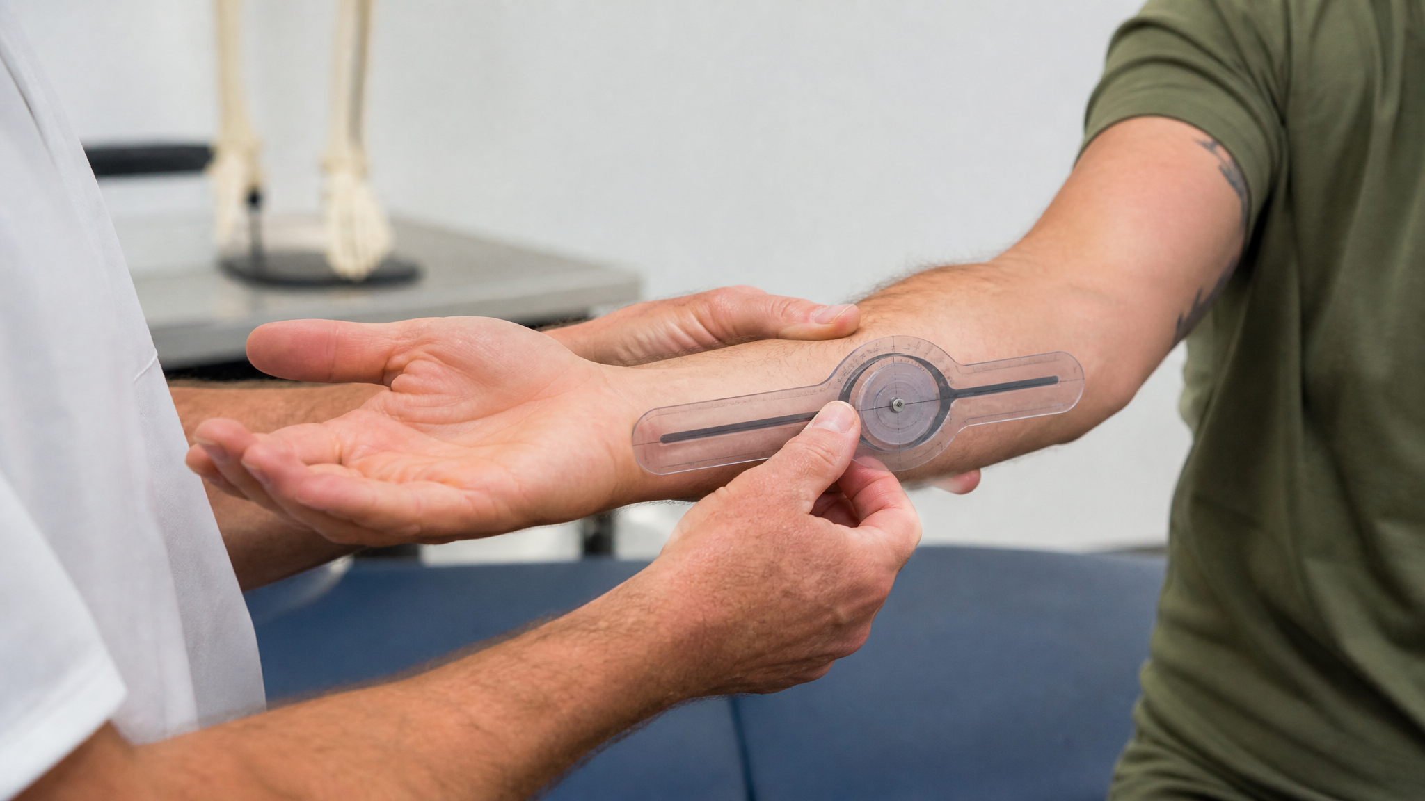 A clinician holding a veteran forearm horizontally and measuring rotation with an inclinometer, the palm positioned mid-rotation