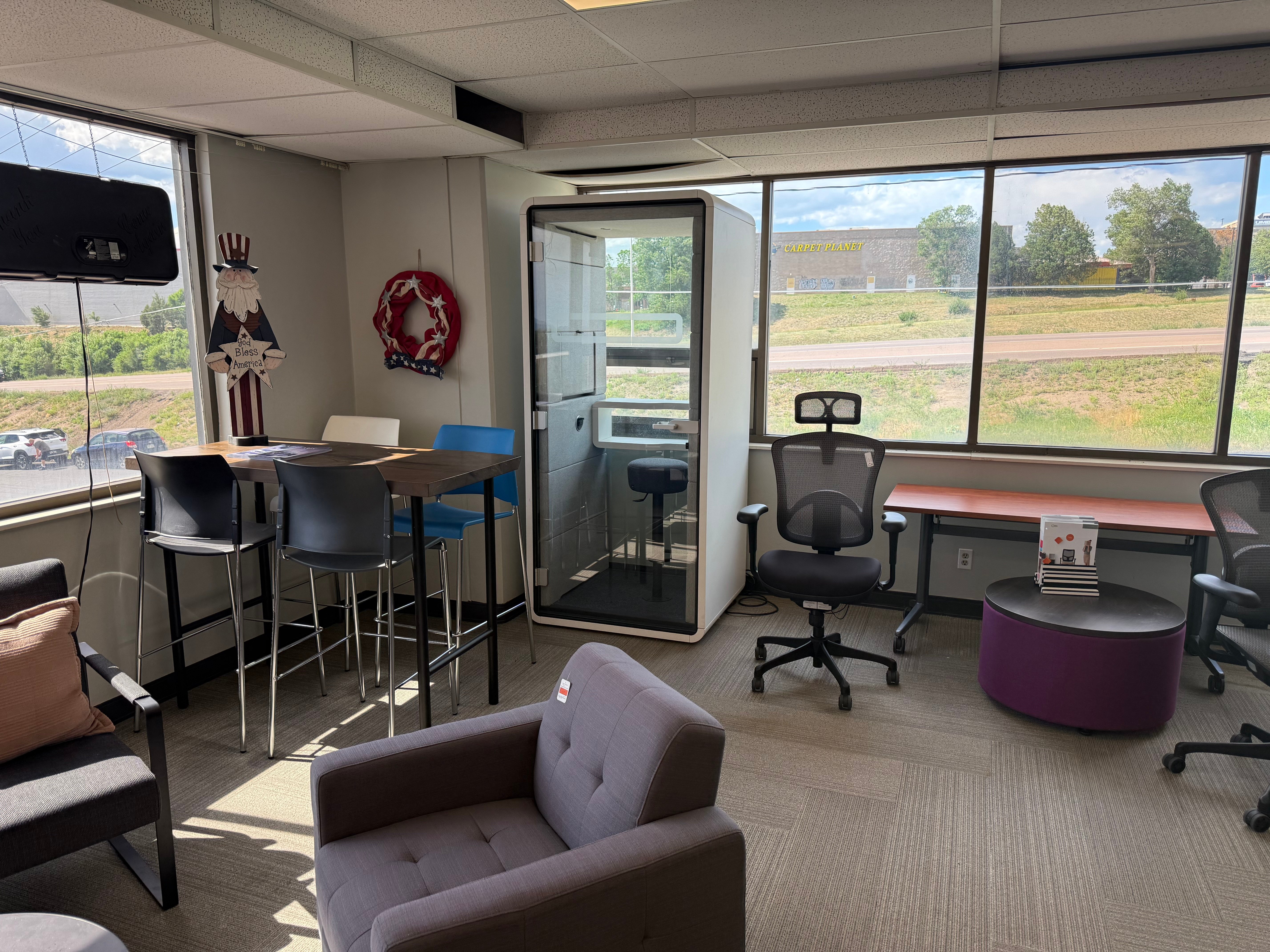 Phone booth, bar-height seating, and lounge furniture on display