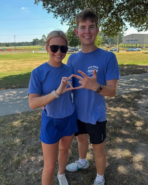 Landon and another adult standing together outdoors.