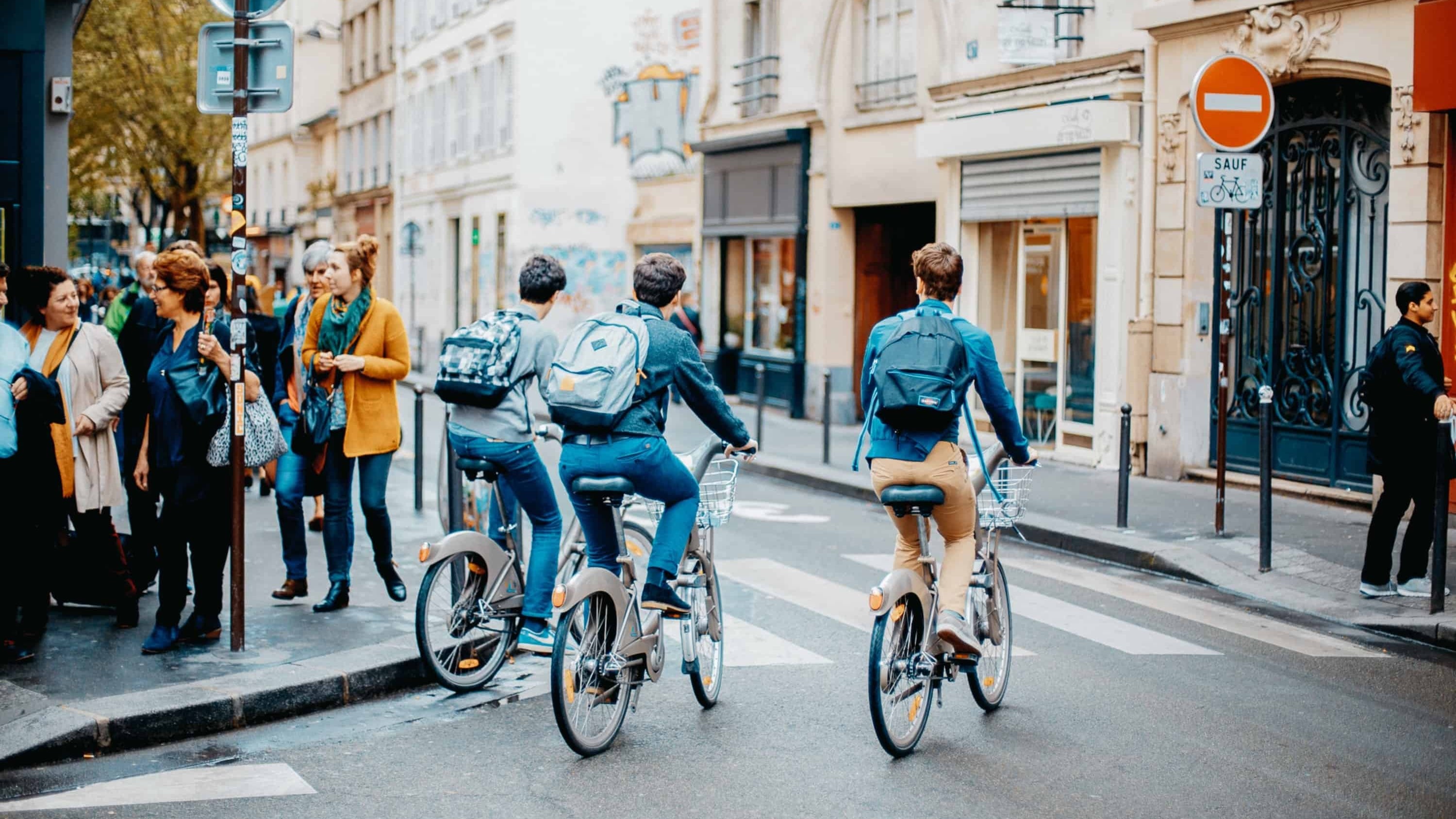 Pessoas pedalando em cidade moderna com estações de bike