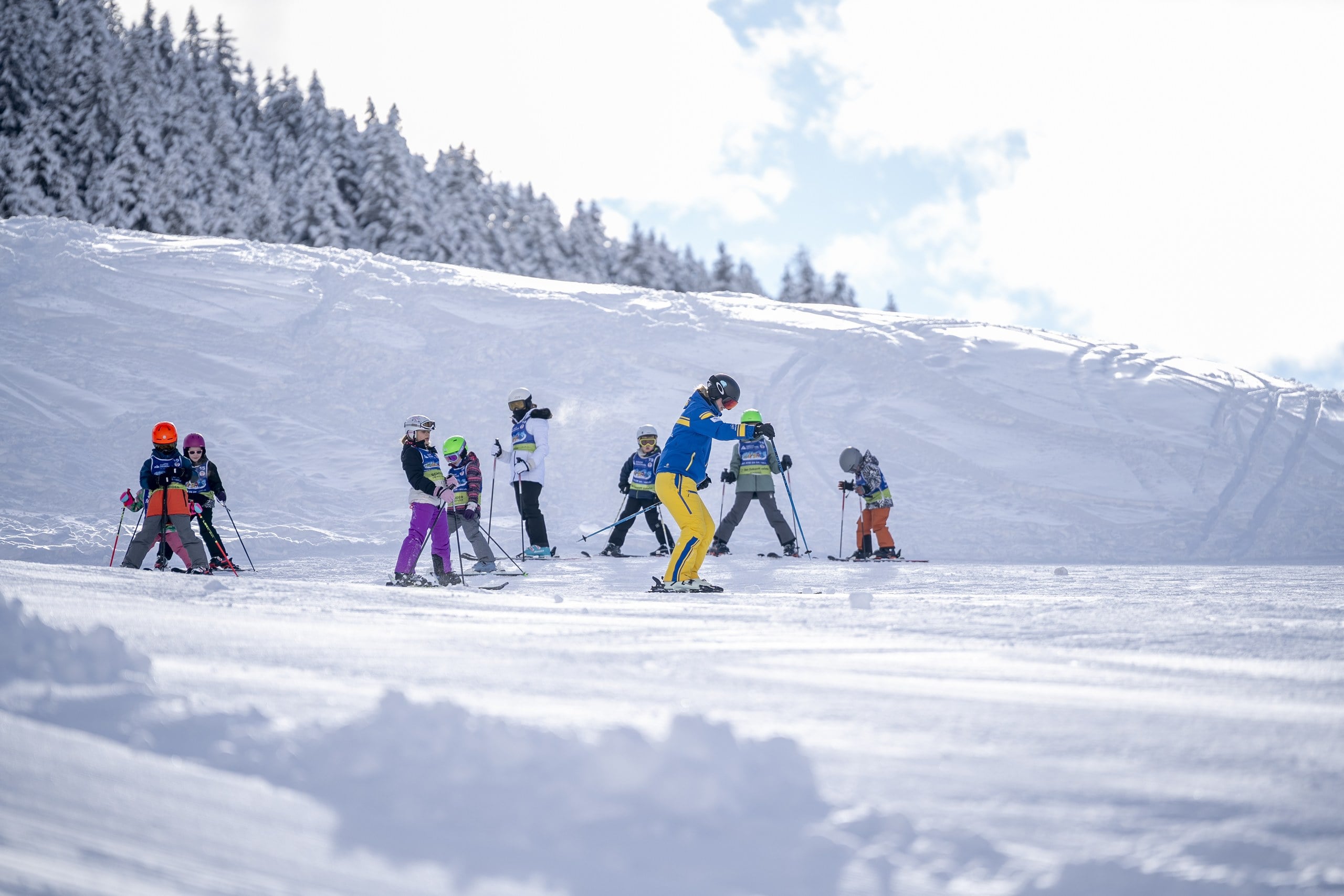 Children in a ski lesson on a snowy alpine slope