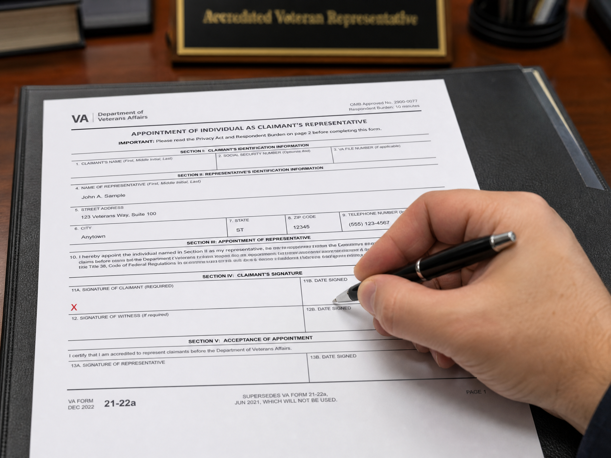 A close-up of a hand signing VA Form 21-22a, the appointment of an accredited representative