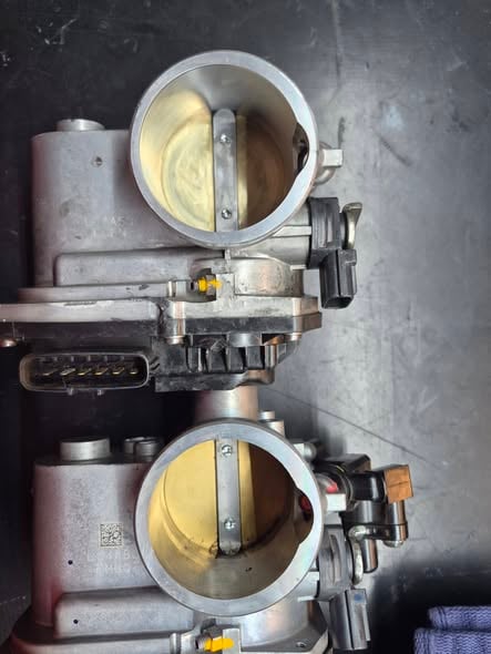Bored throttle body next to a stock one