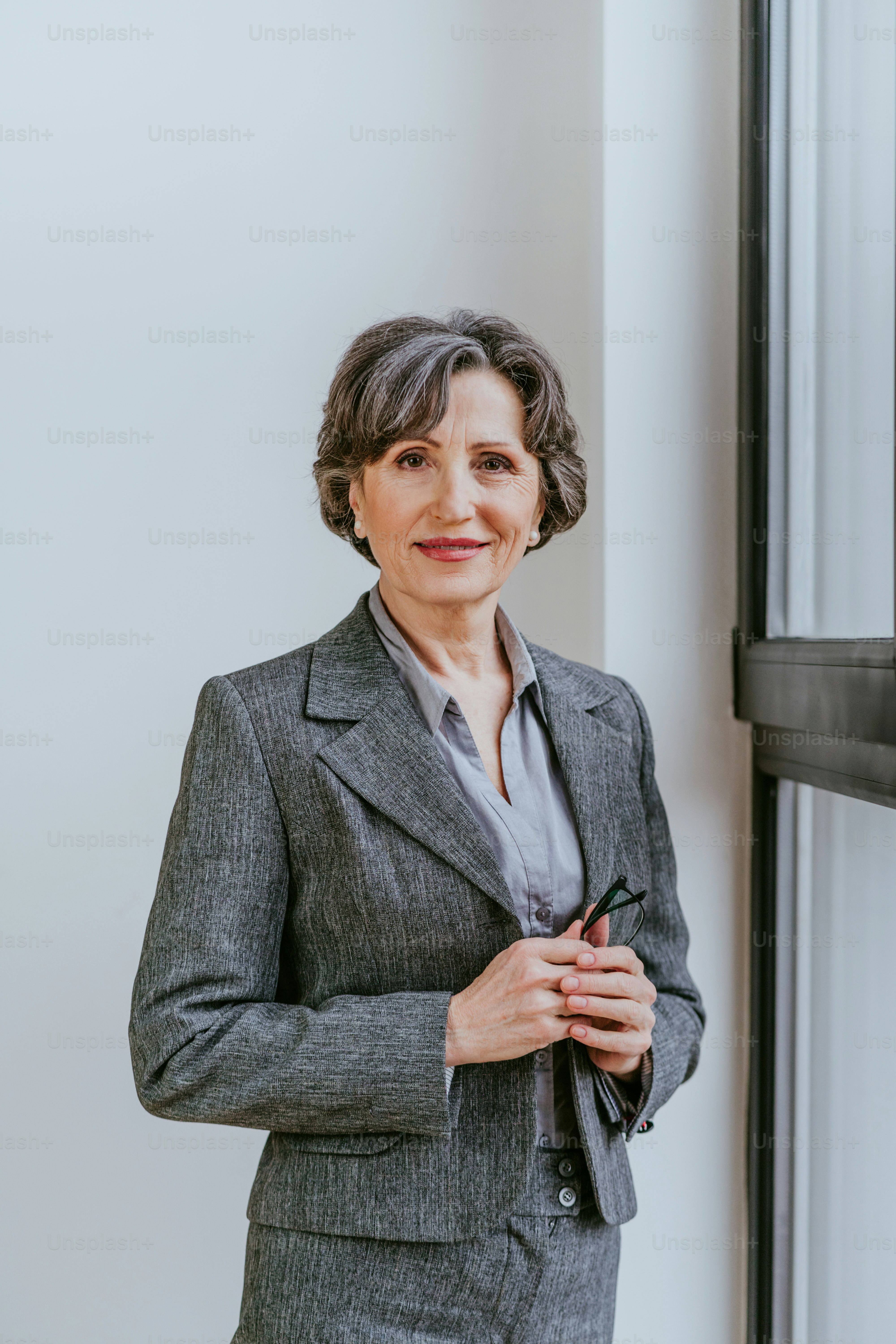 Professional portrait of a Latina woman in her 50s wearing a grey business suit serving as a veterans benefits advocate