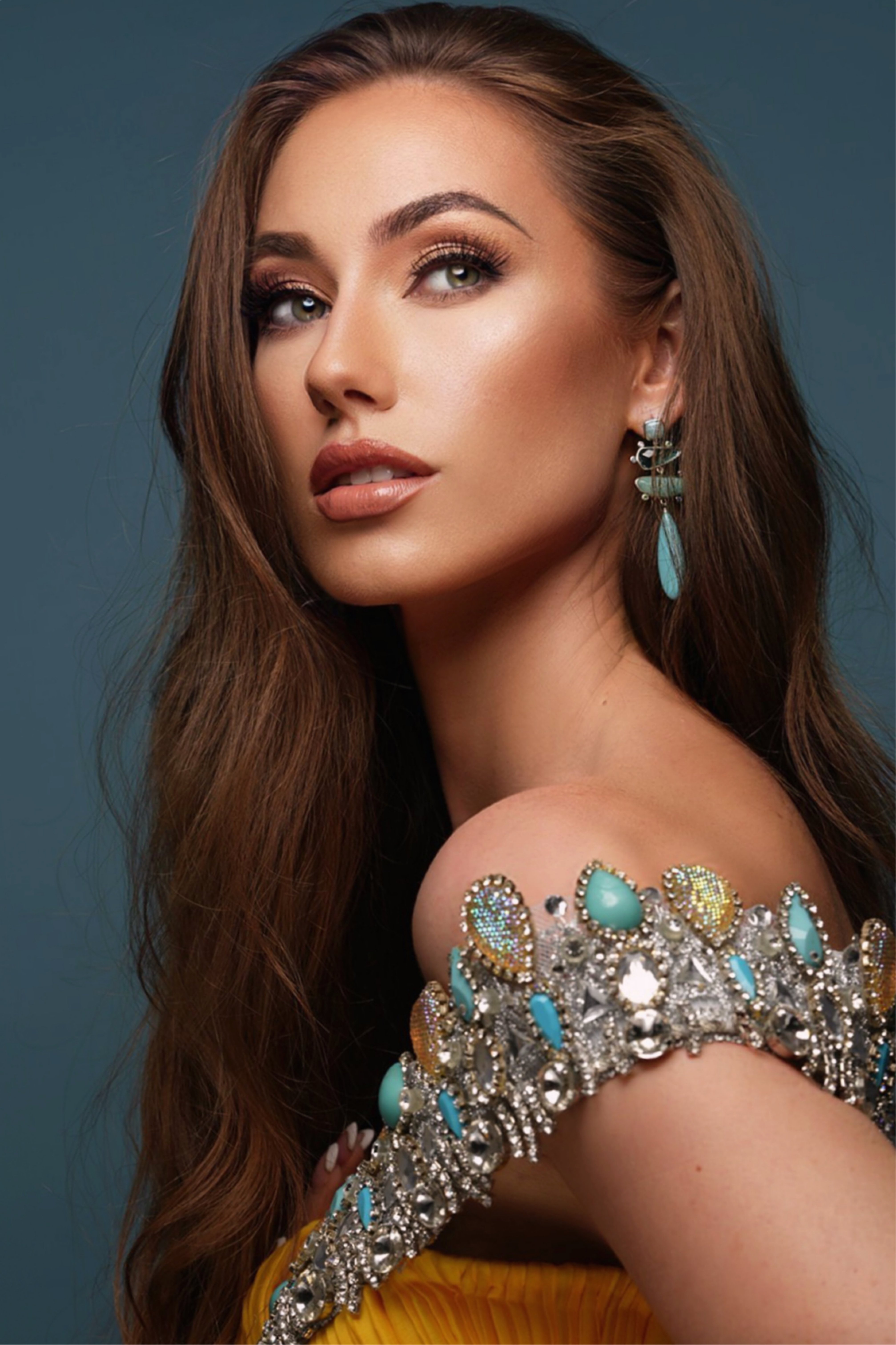 Pageant headshot with turquoise jewelled dress and dramatic styling