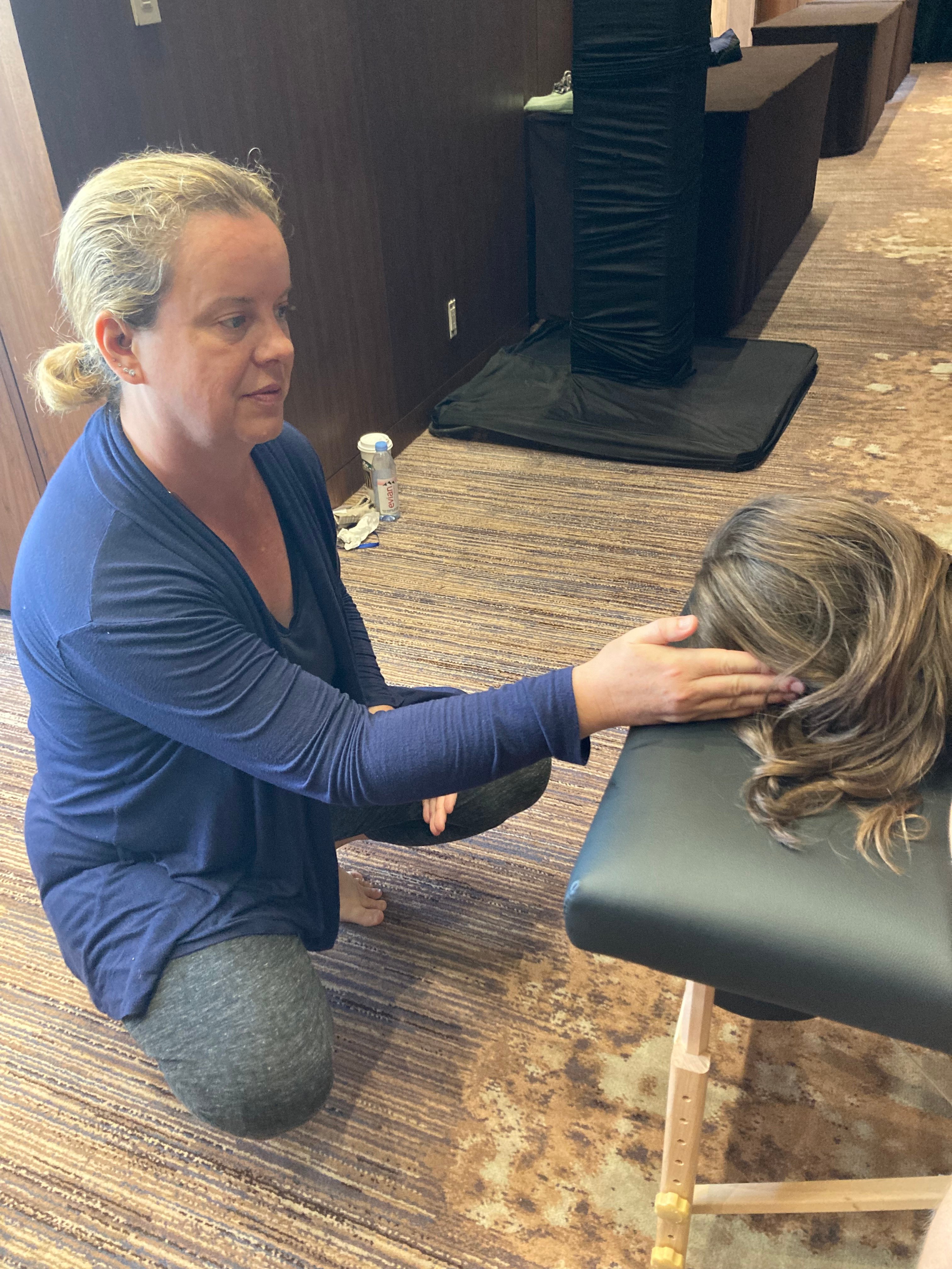 Sarah performing gentle light-touch Spinal Flow work at the immersive training event