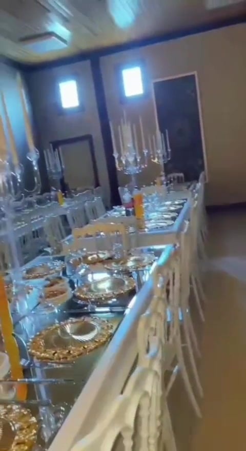 Altın tabaklı uzun masa kurulumu — mumlar ve çiçek süslemesi