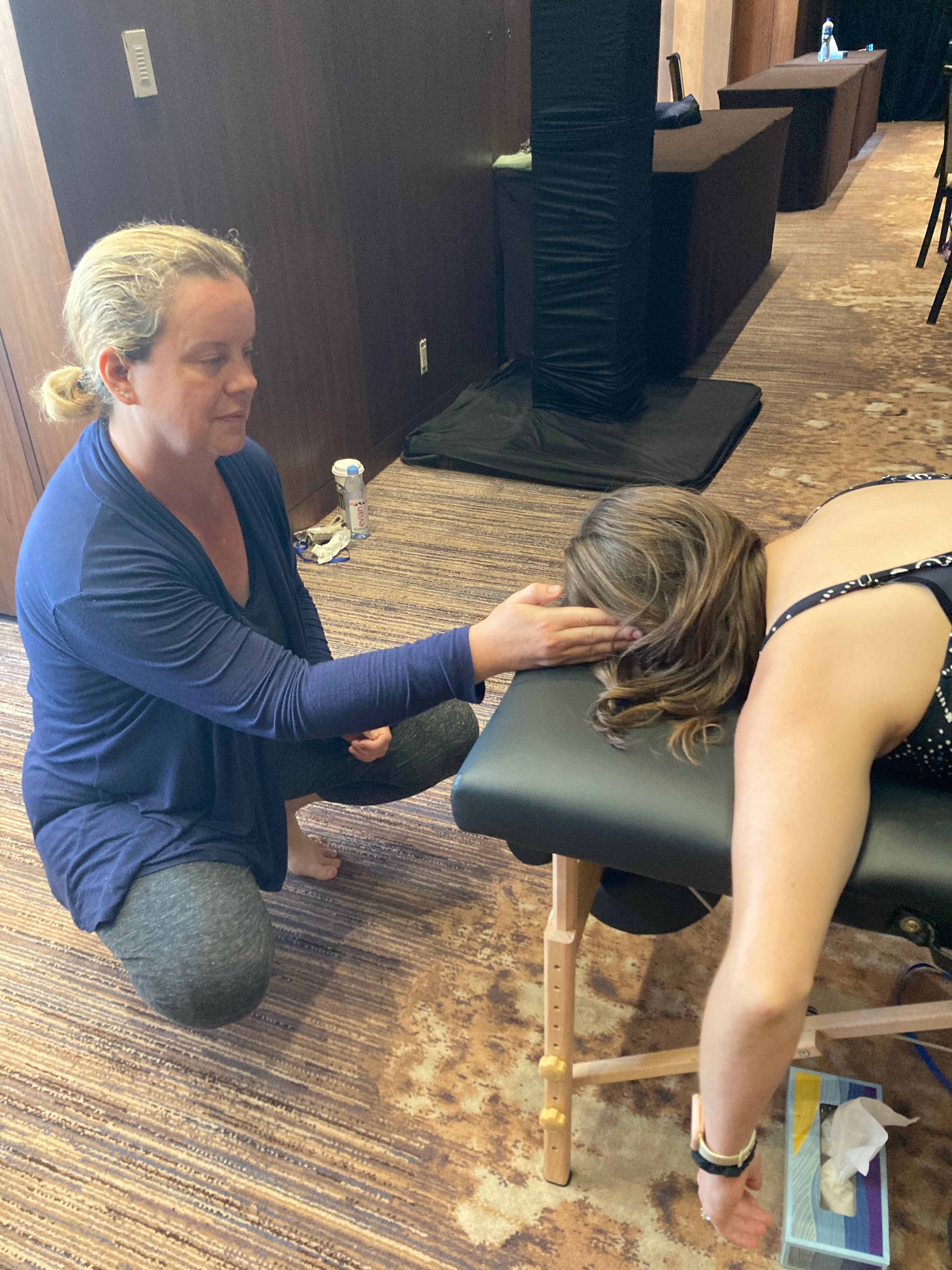 Close-up of Sarah performing precise Spinal Flow light-touch technique on a client