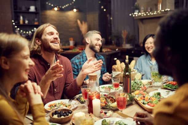 Diverse group of young professionals laughing at dinner