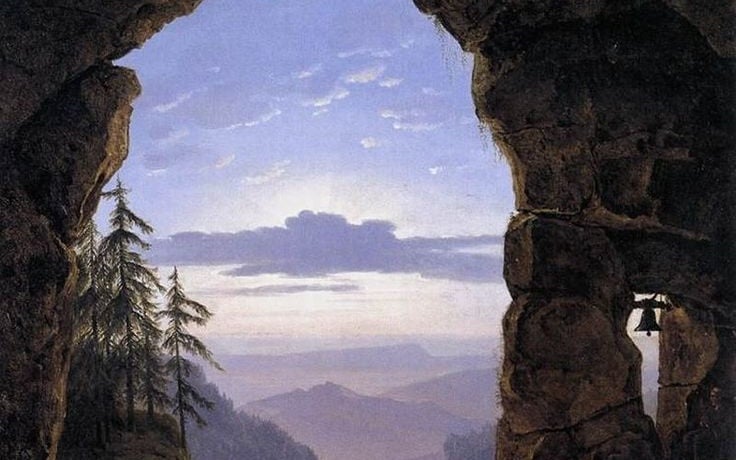 A view through a dark rock arch toward a luminous distant landscape