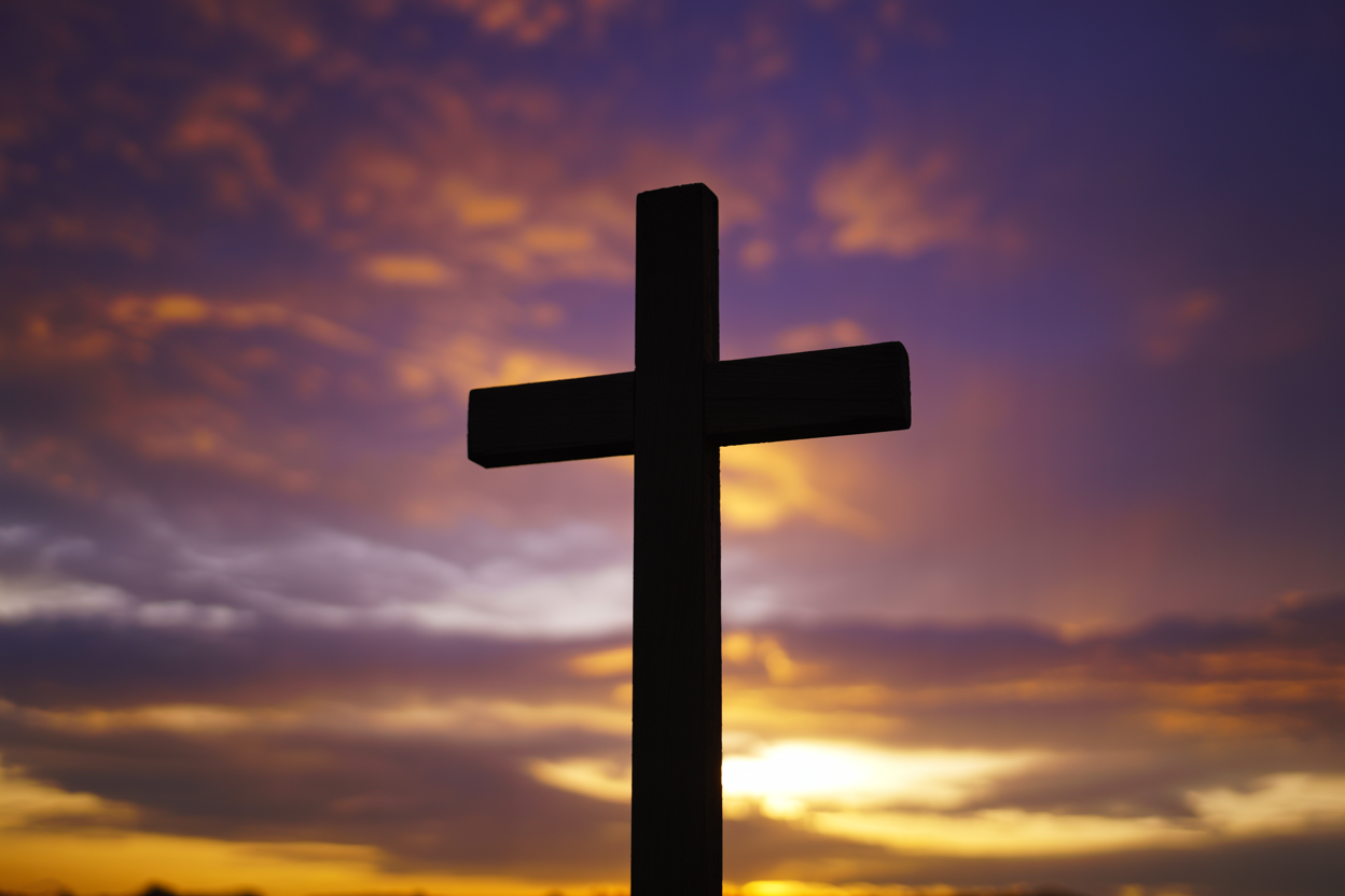 Cross silhouette against sunset sky