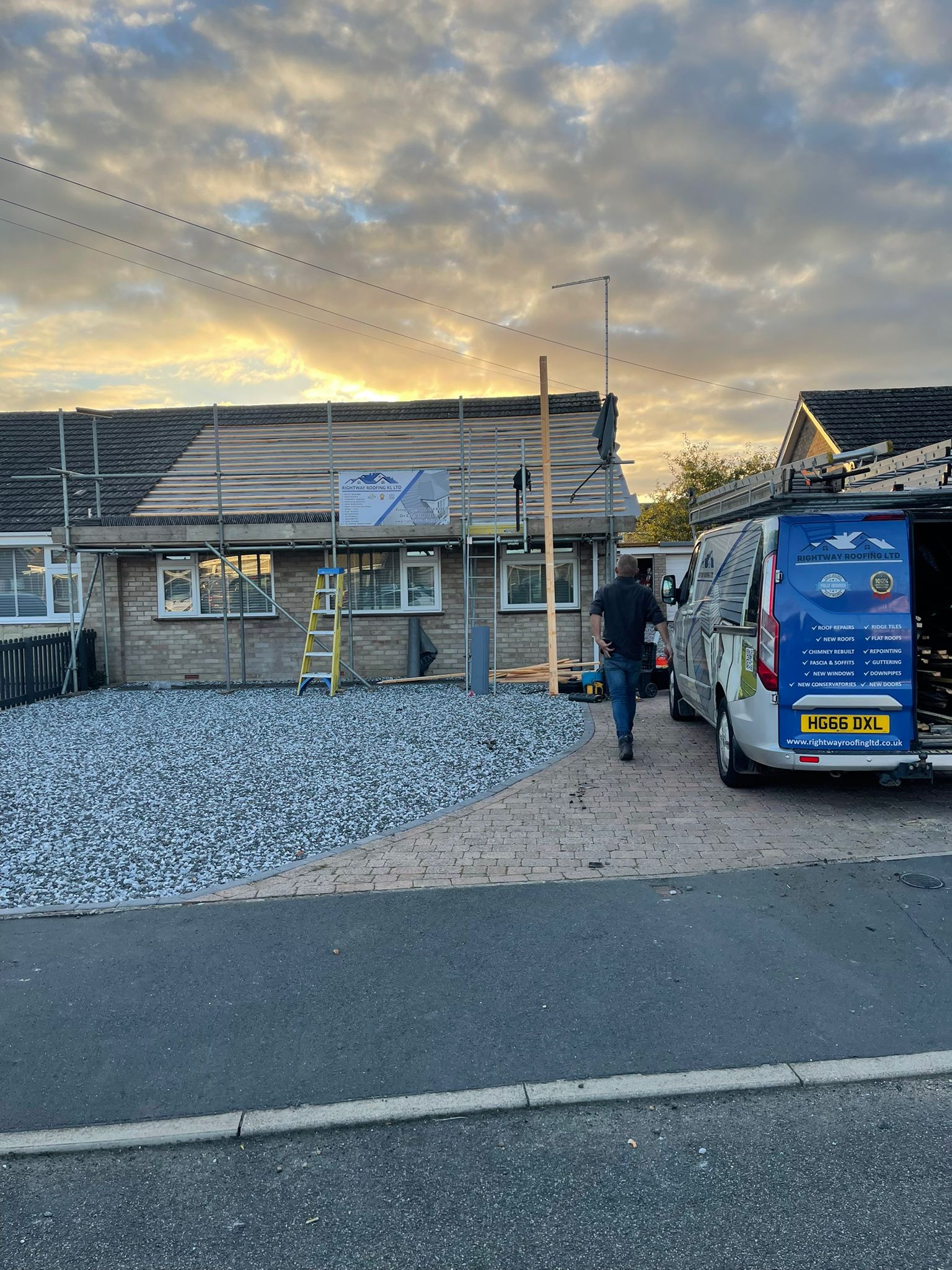 Dusk roofing work showing exposed roof structure during major repair