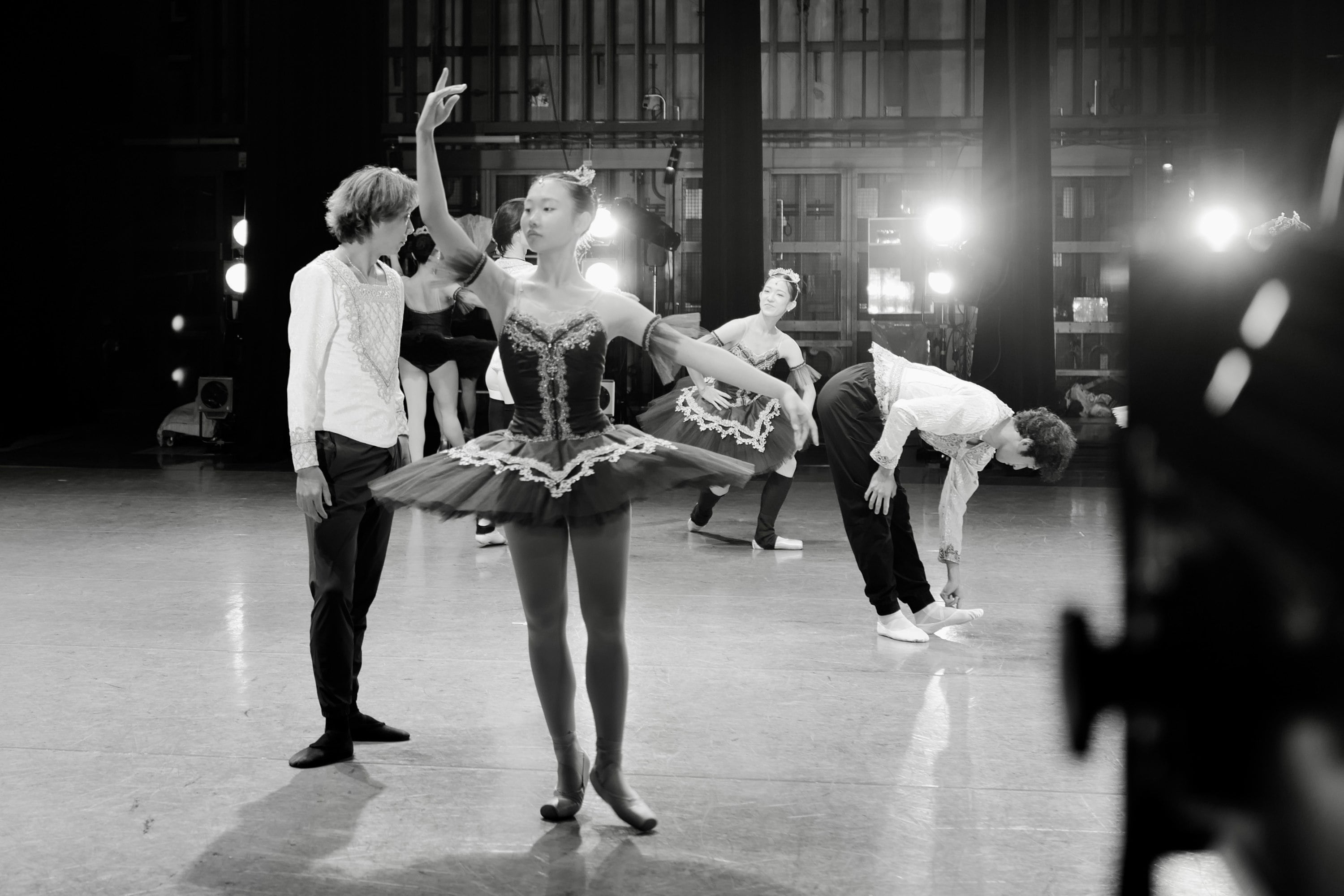 Classical ballet dancer in an elegant arabesque pose in a warm studio