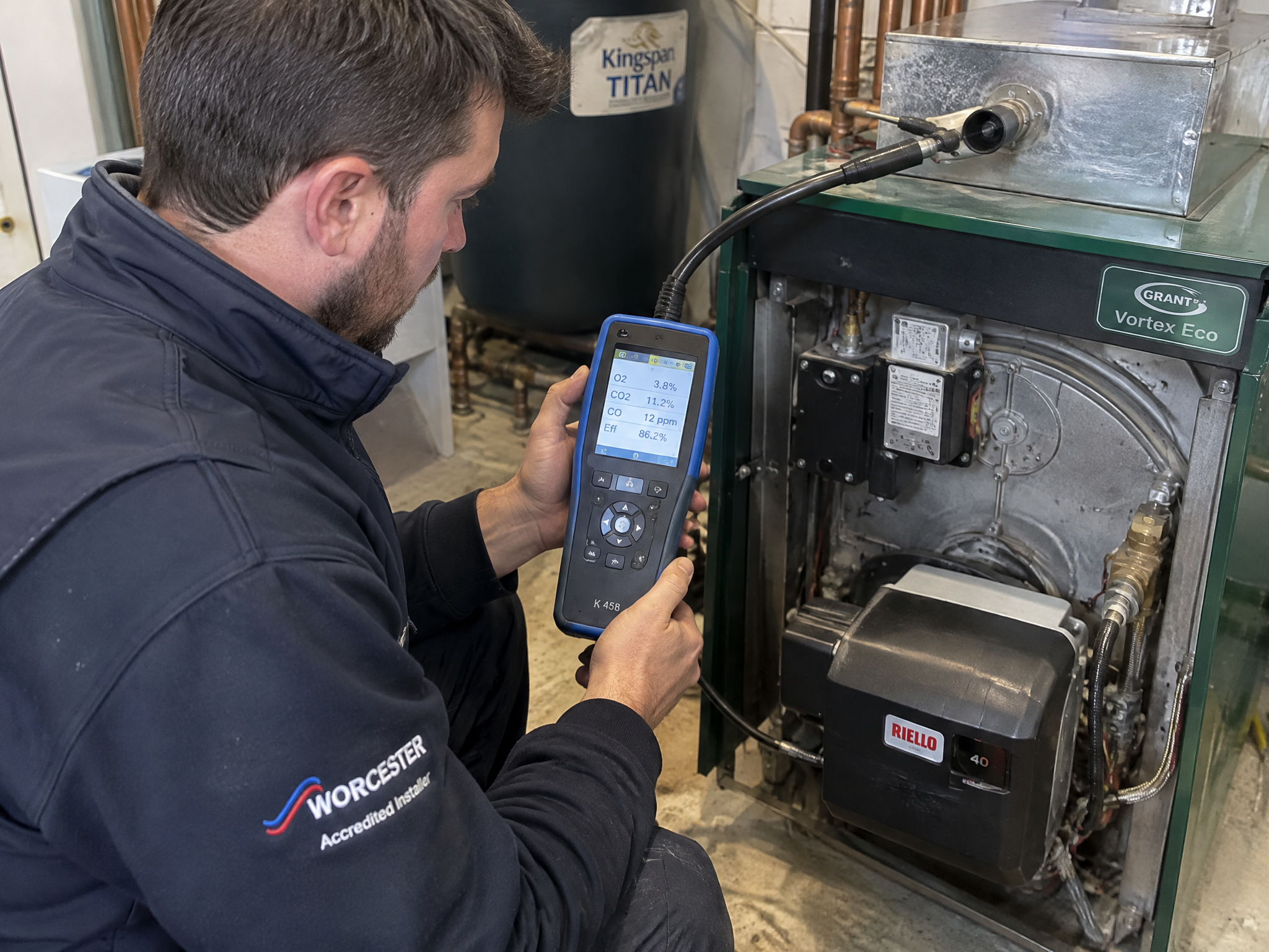 Engineer using a flue gas analyser to diagnose an oil boiler fault