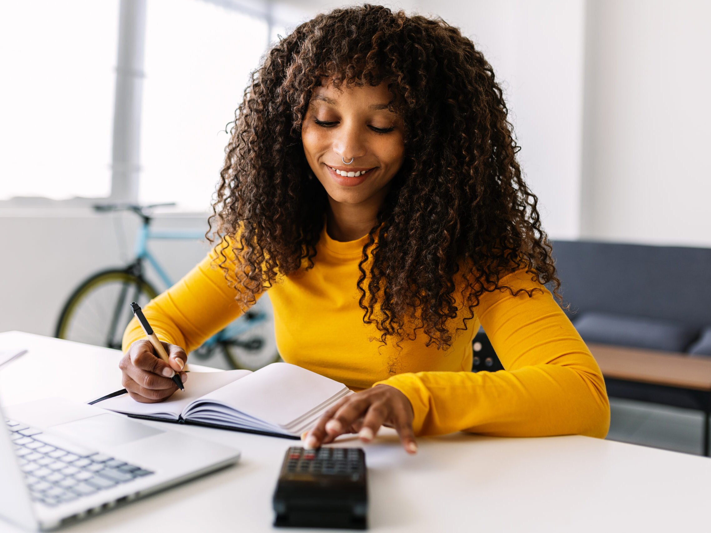 Mulher sorridente gerenciando finanças no laptop