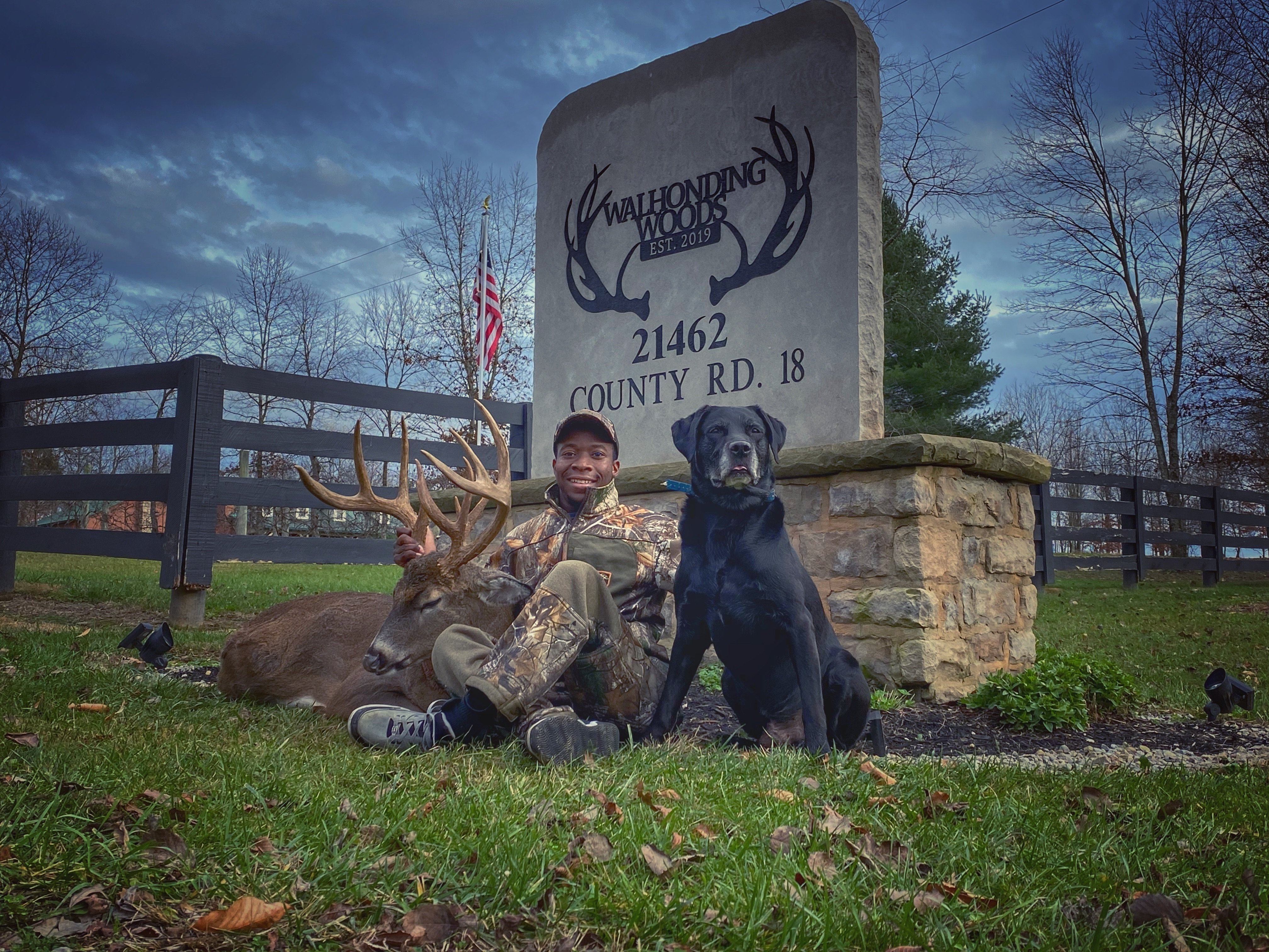 Joshua Carney with whitetail buck and his black lab at Walhonding Woods
