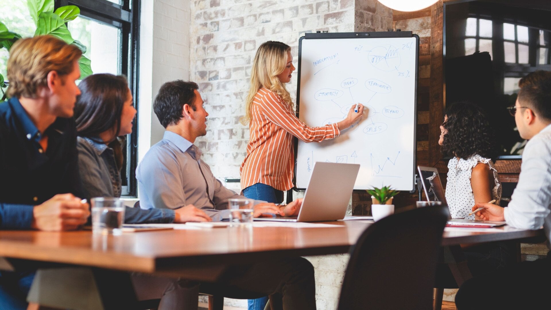 Team collaborating in meeting room with digital whiteboard