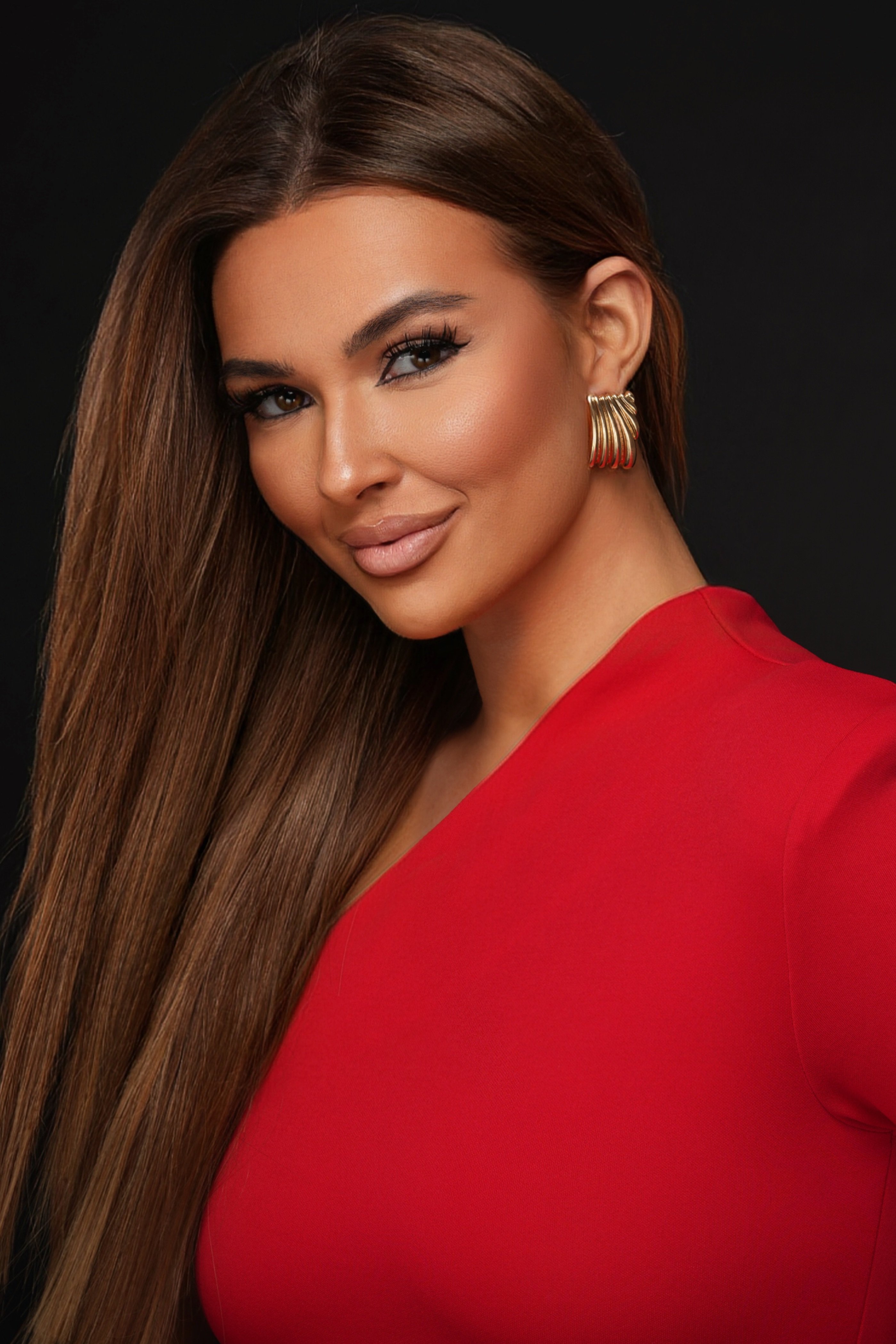 Sleek pageant headshot in red dress with gold earrings