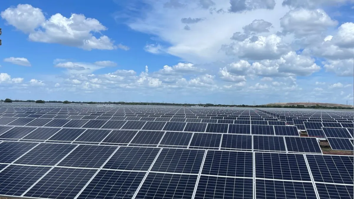 Solarpark mit modernen Photovoltaik-Modulen unter blauem Himmel
