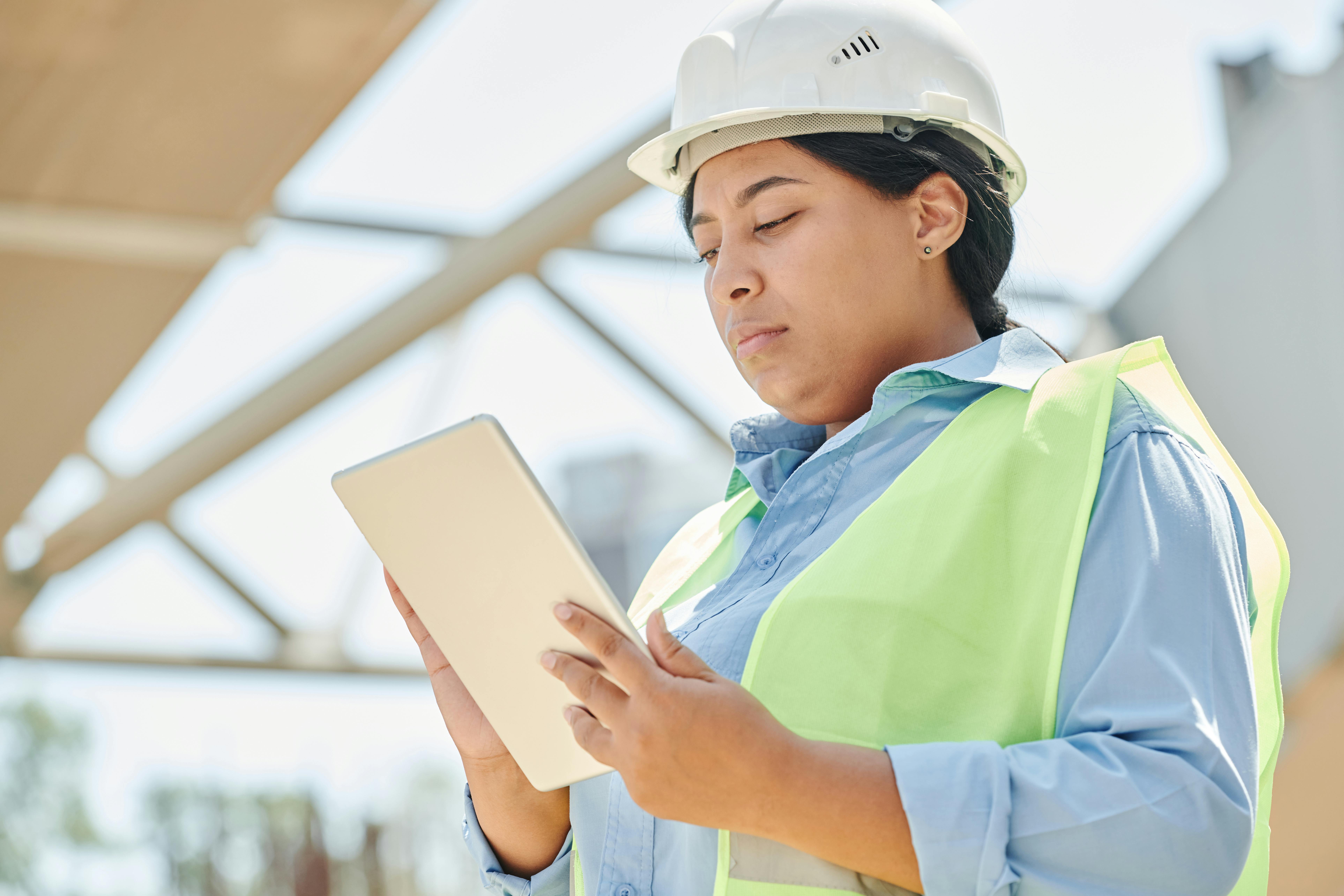 Professional contractor reviewing website plans on a tablet at a job site