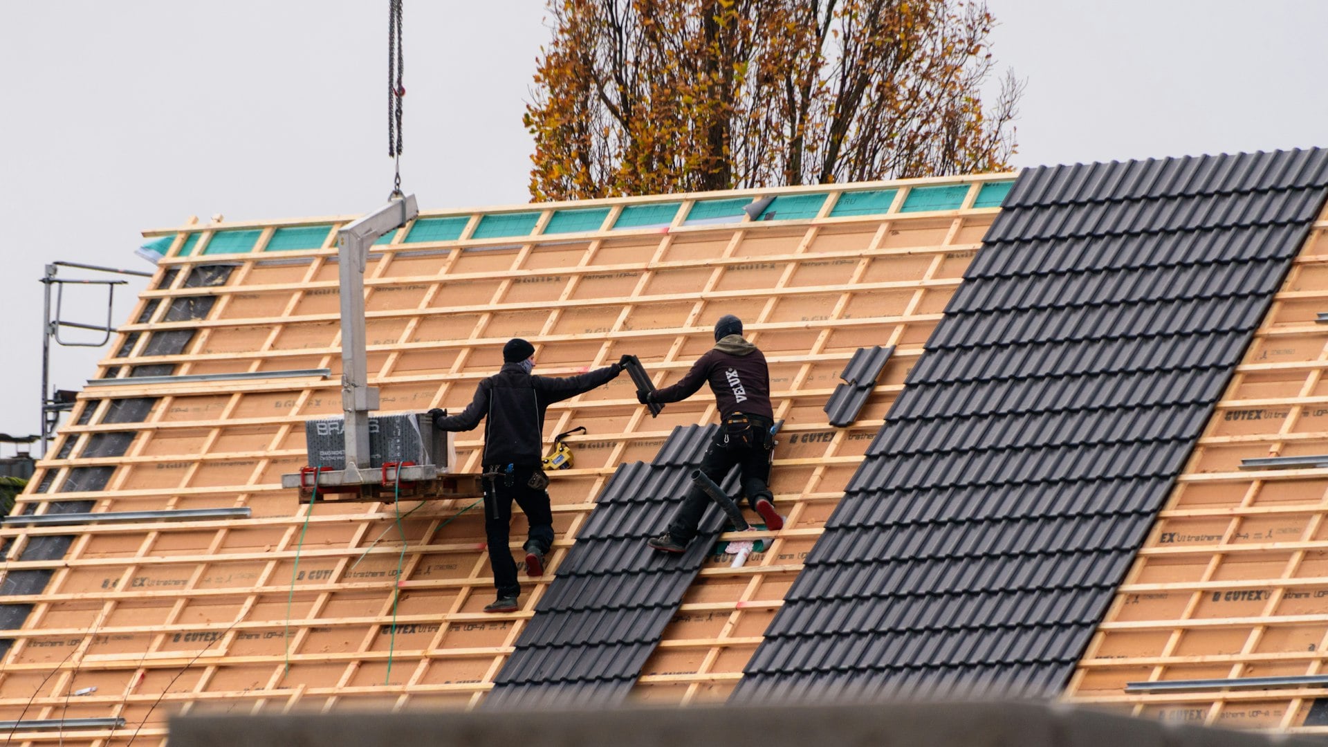 Roofers laying tiles on battens