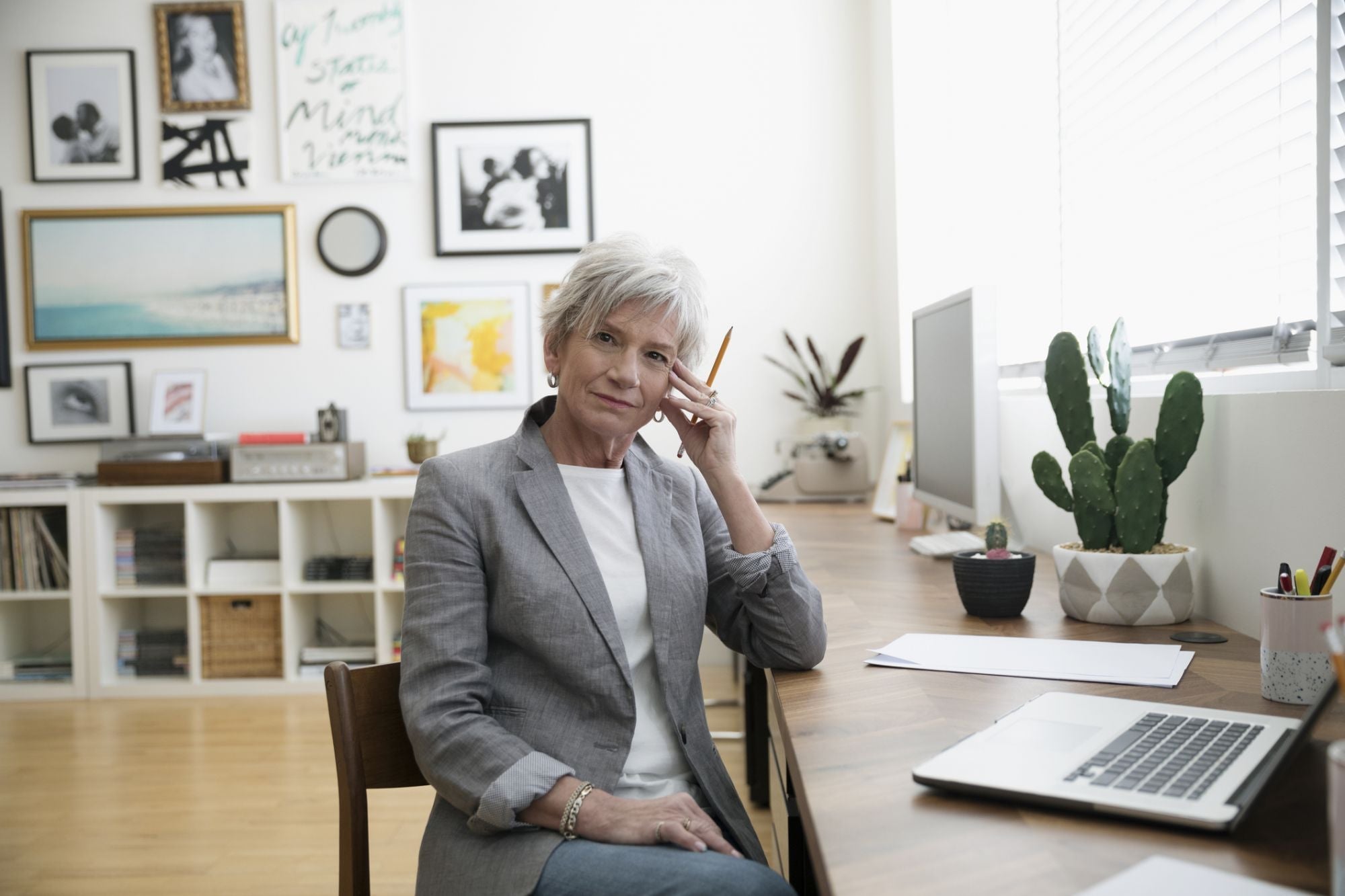 A confident white woman veterans disability advocate in professional attire seated at a clean office desk