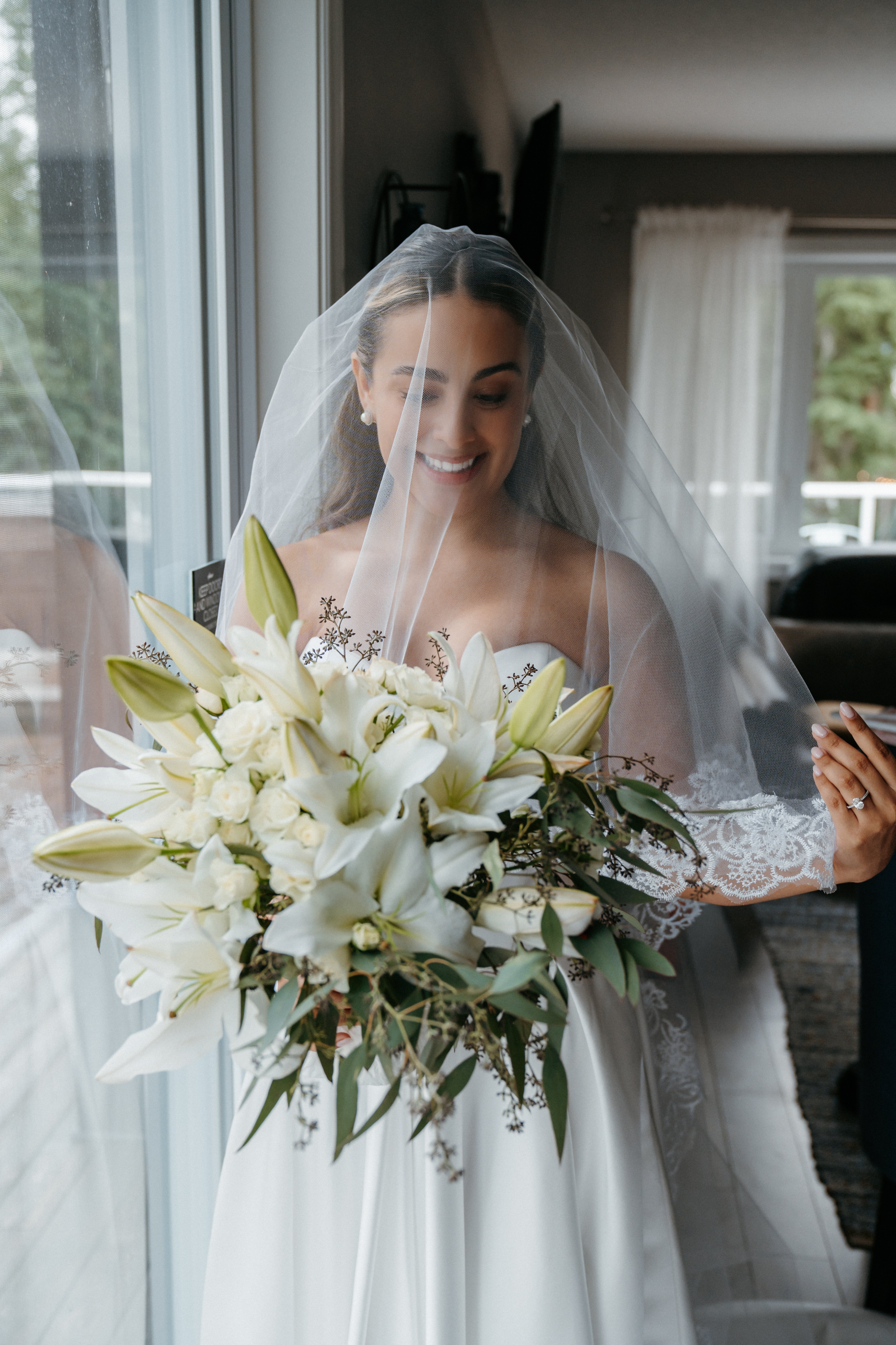 Happy couple posing with elegant white bouquet in lush garden