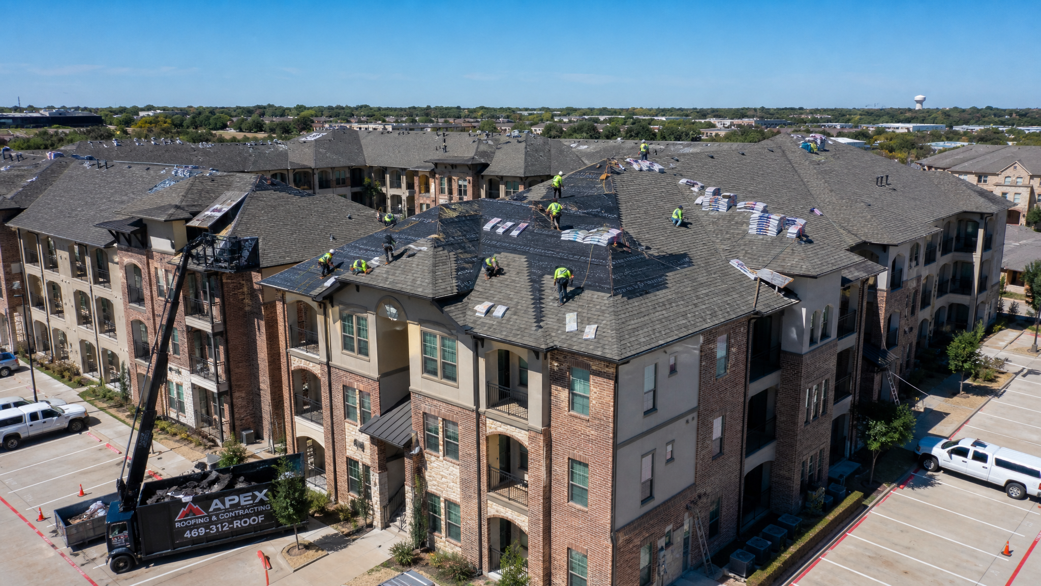 Professional roofing crew working on a large multifamily apartment complex in North Texas