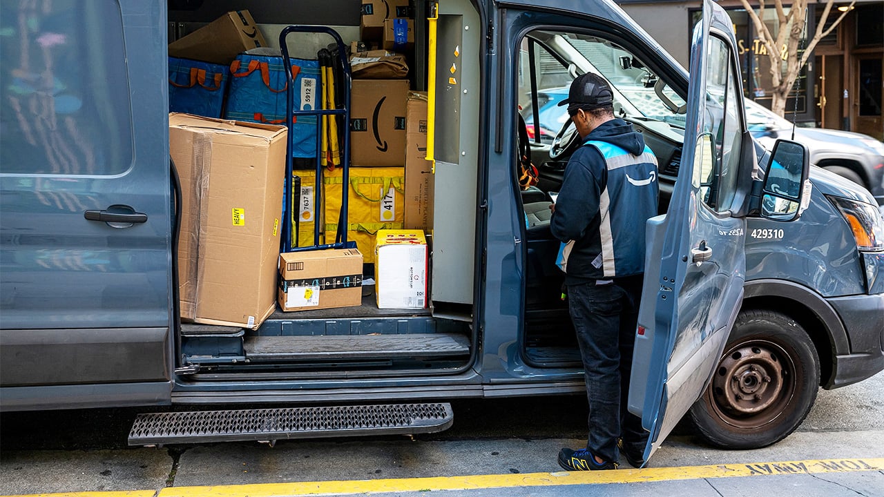Delivery driver loading parcels into a transit vehicle for dispatch