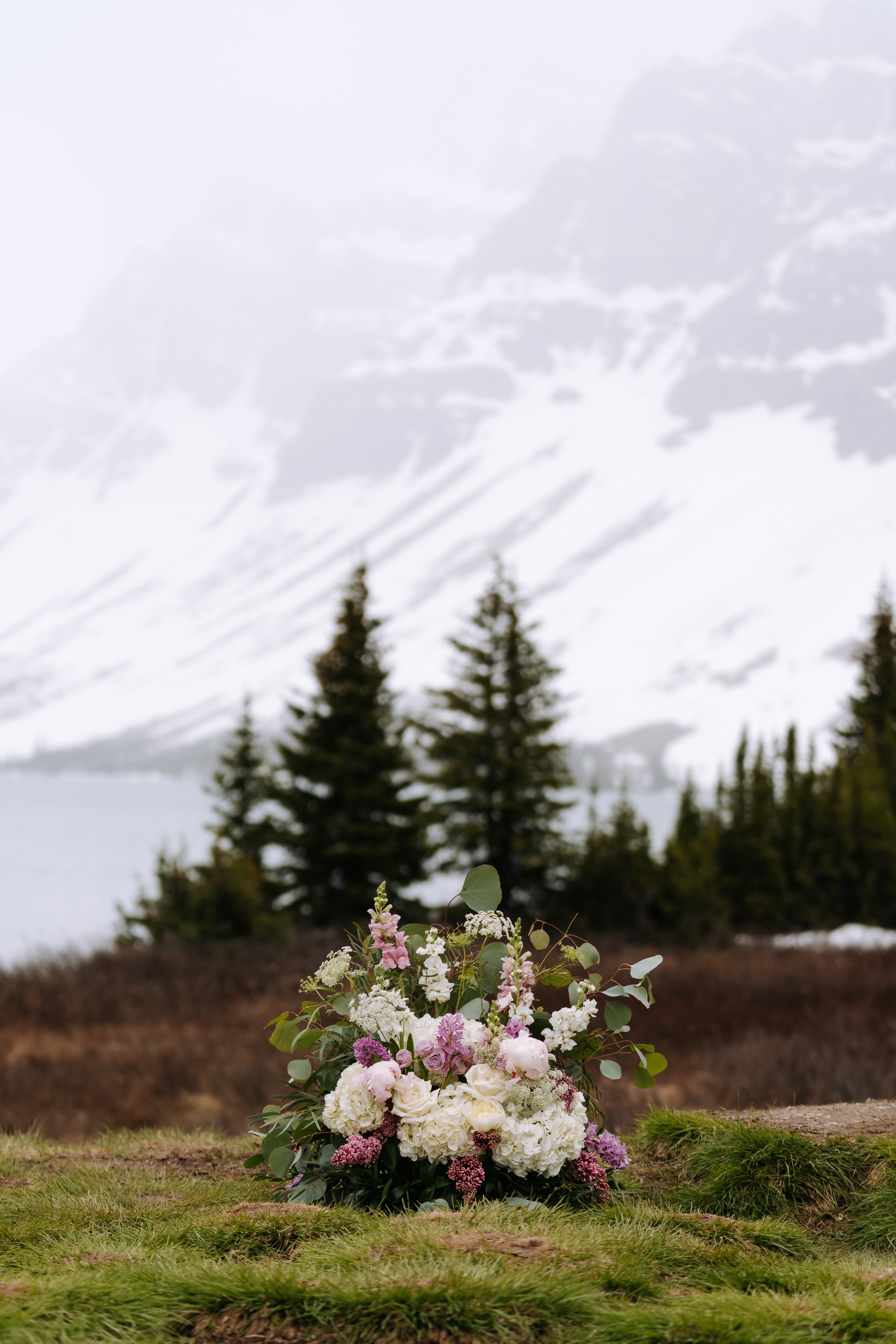 Bride by the lakeside with flowing veil and bouquet