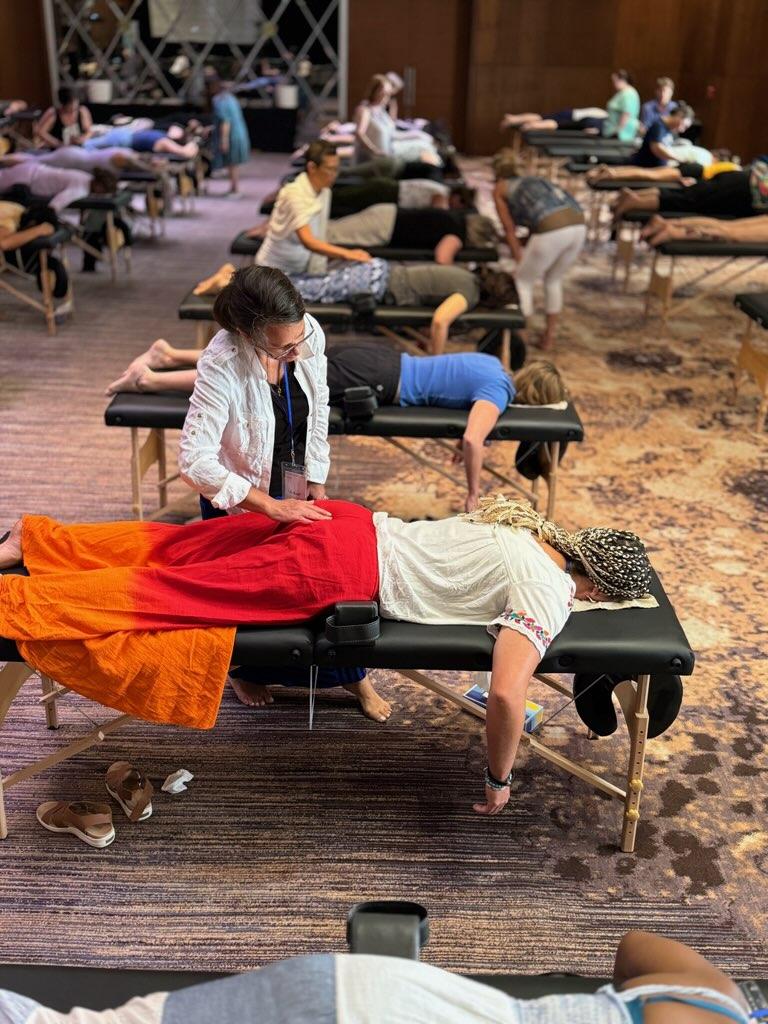 Practitioners working with clients during the Spinal Flow immersive training in Playa del Carmen