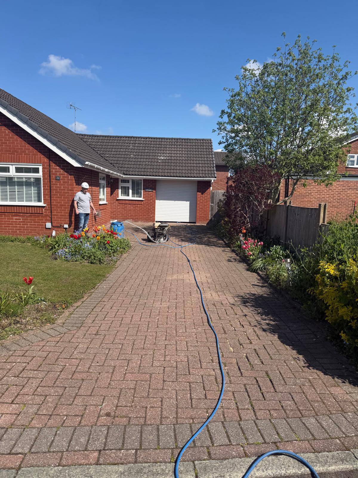 Operative inspecting freshly cleaned block-paved driveway