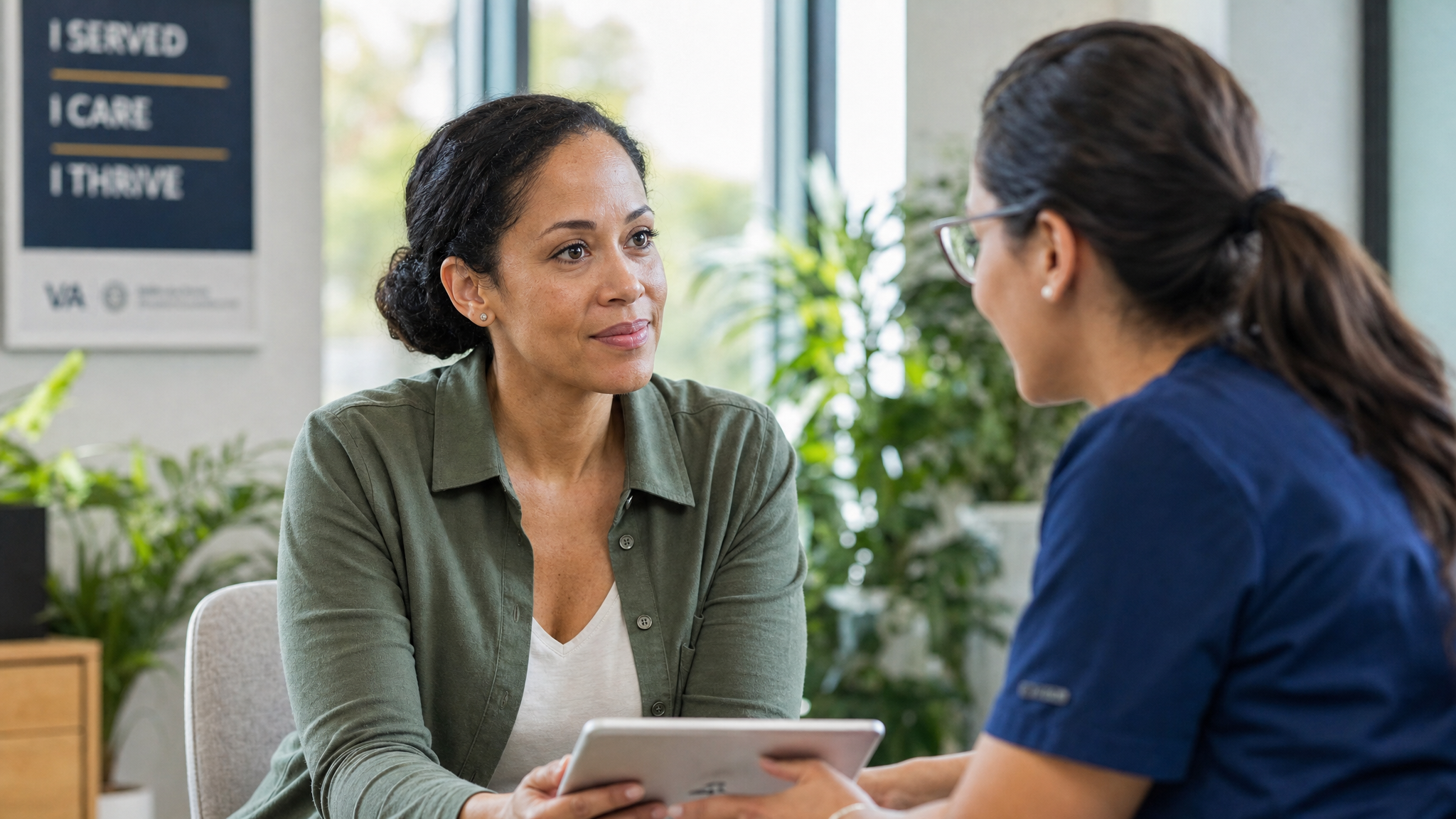 A post-9/11 mixed-race female veteran reviewing health information on a tablet with a clinician