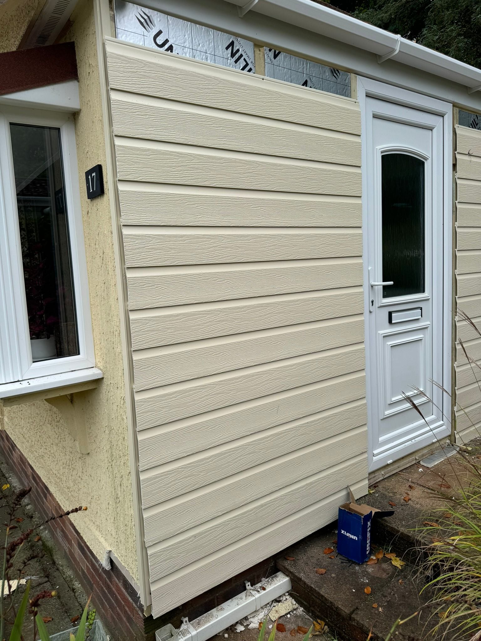 Completed cream horizontal cladding with white uPVC door on park home number 17