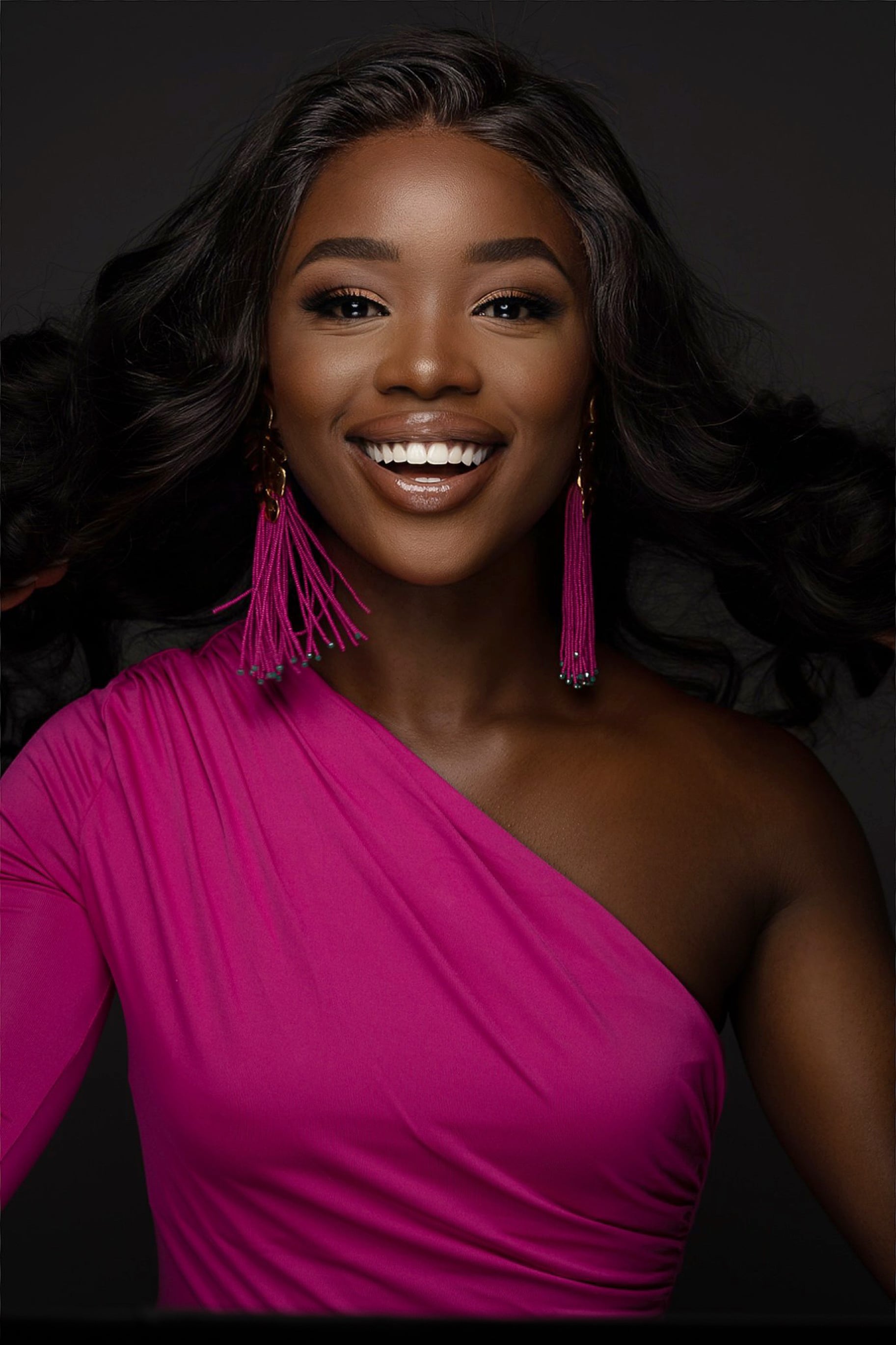 Radiant portrait in pink one-shoulder dress with tassel earrings