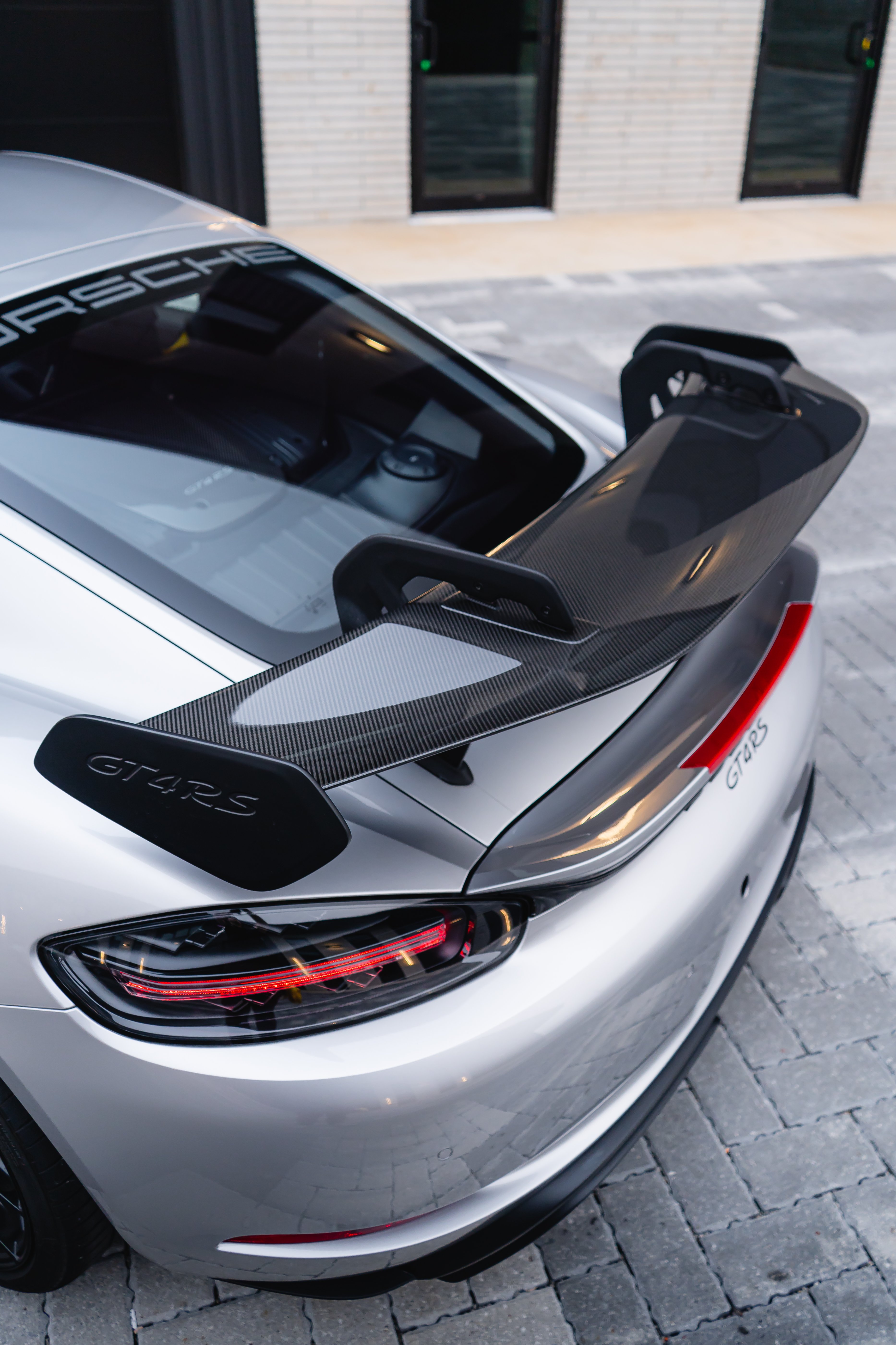 2023 Porsche GT4 RS rear three-quarter view with carbon fiber wing and GT4RS badge