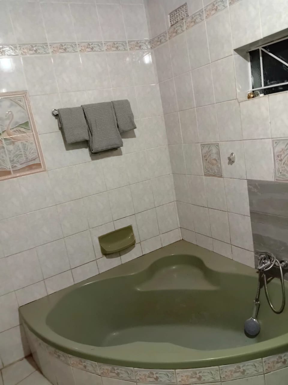 Private bathroom with corner bathtub at The Little Den Gweru