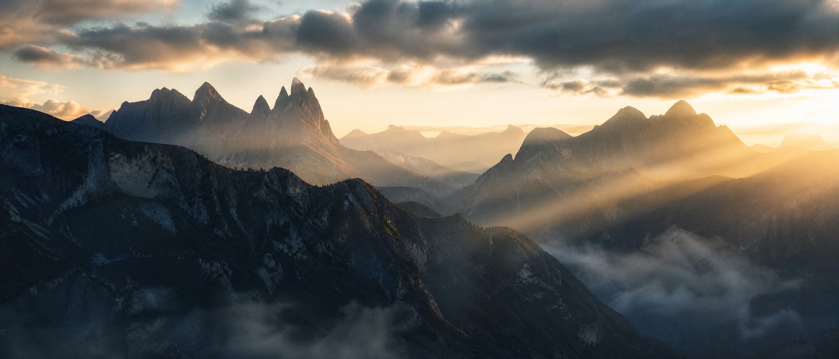 Golden sunrise breaking through mountain peaks — a new beginning in wellness