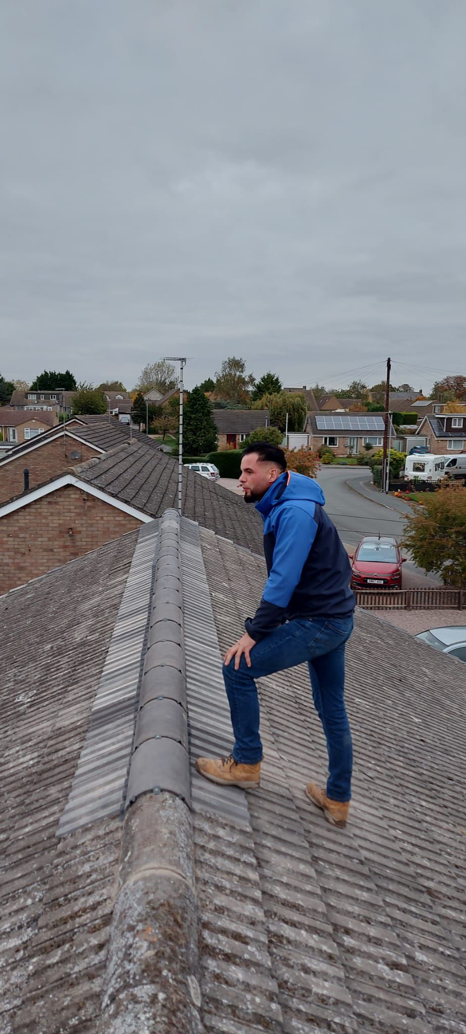 Gutter cleaning service showing before condition with moss buildup