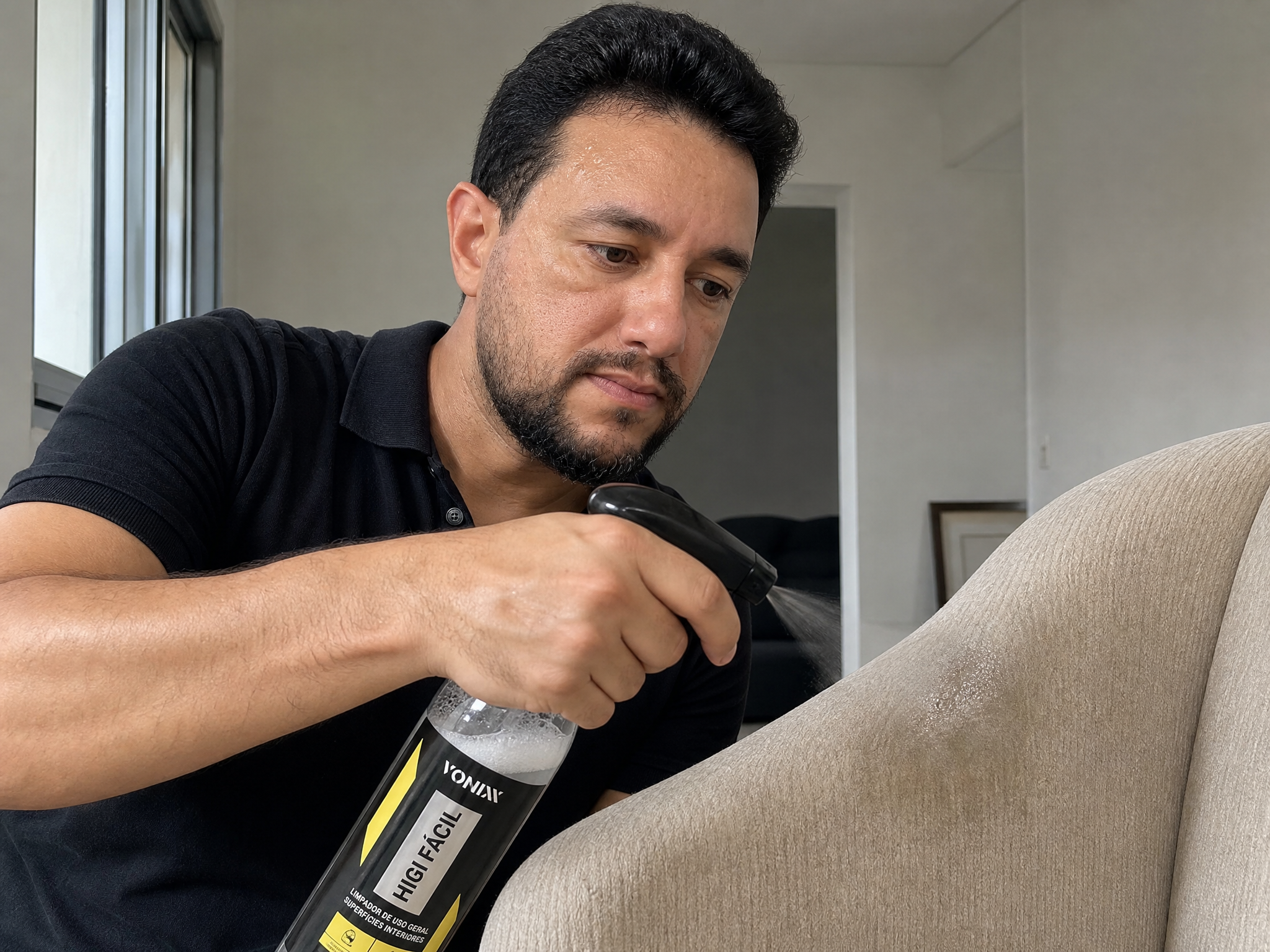 Aplicação de produto de limpeza em poltrona de tecido bege