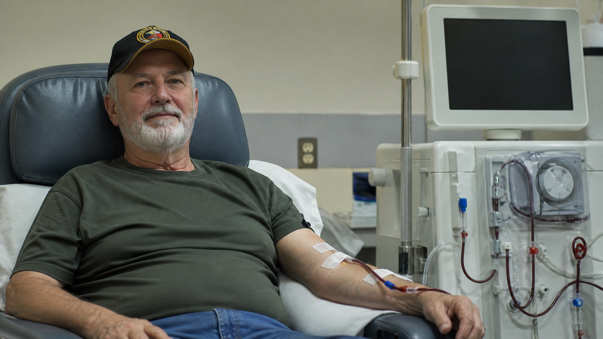 Veteran reclined in a dialysis treatment chair beside a dialysis machine