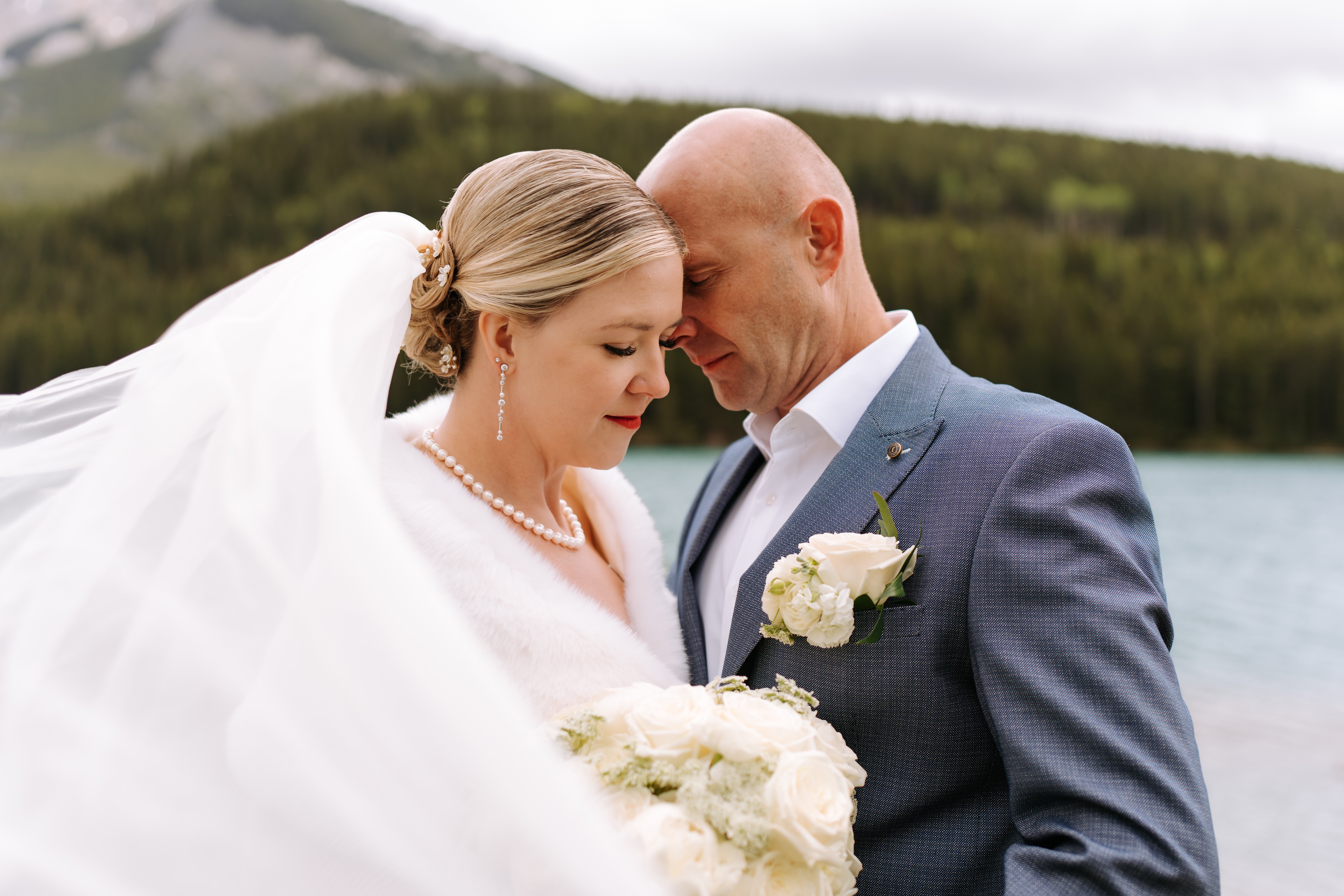 Intimate couple moment with bridal bouquet at Bow Lake, Alberta