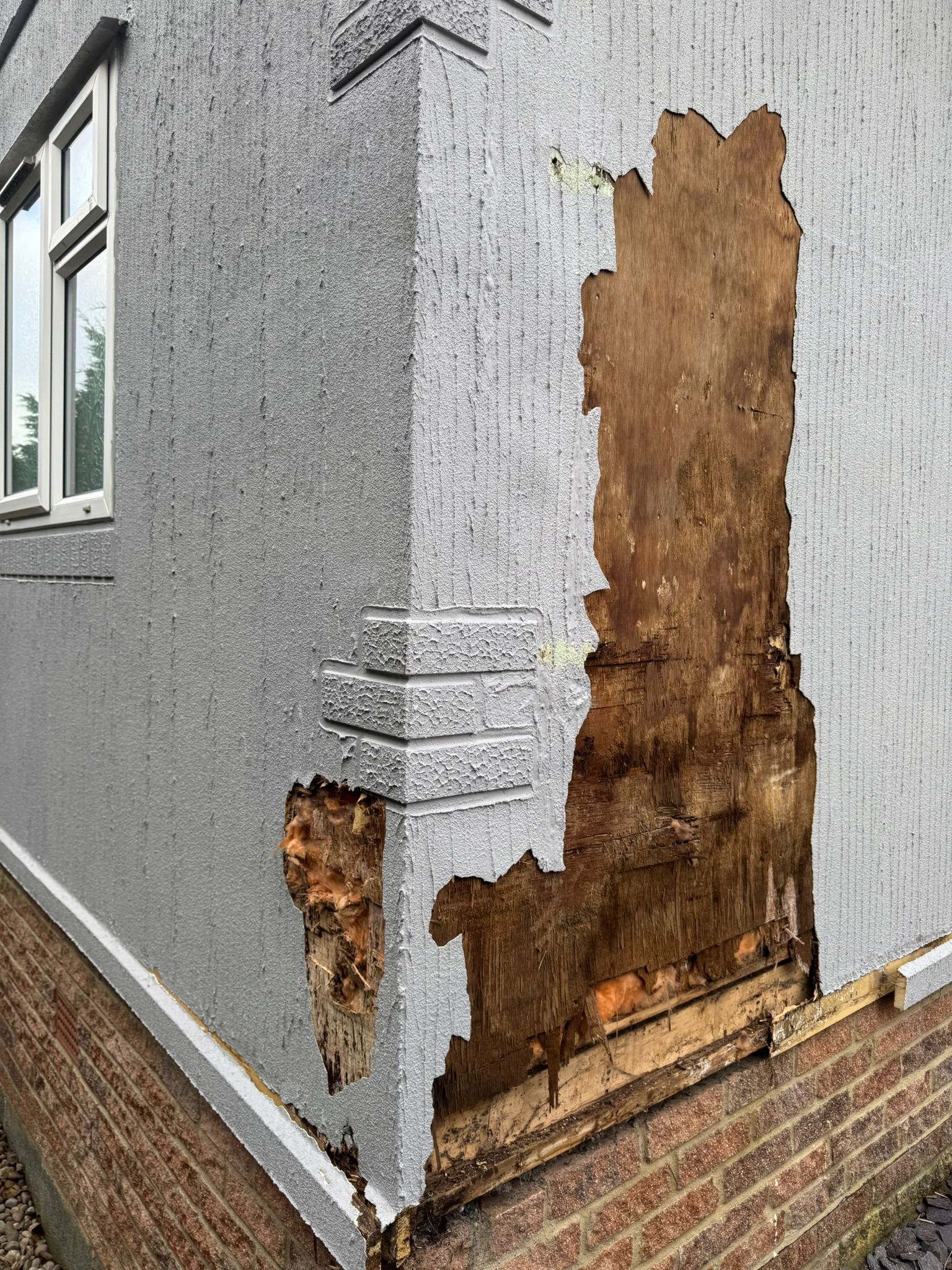 Corner of park home showing extensive wall damage with exposed wood behind cladding