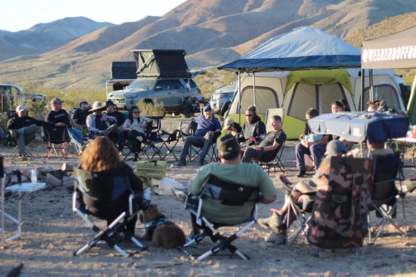 Overlanding community gathered around campfire sharing stories