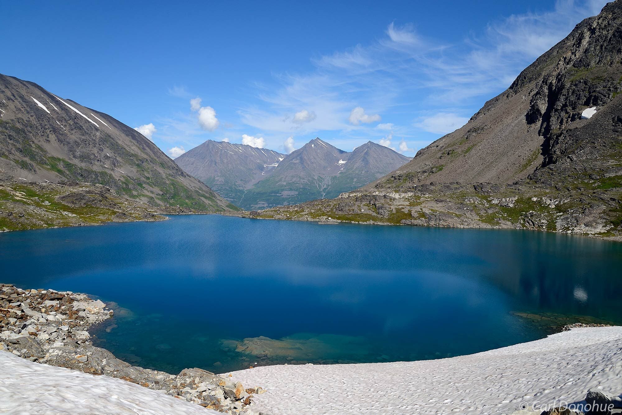 A deep clear glacial lake ringed by mountains