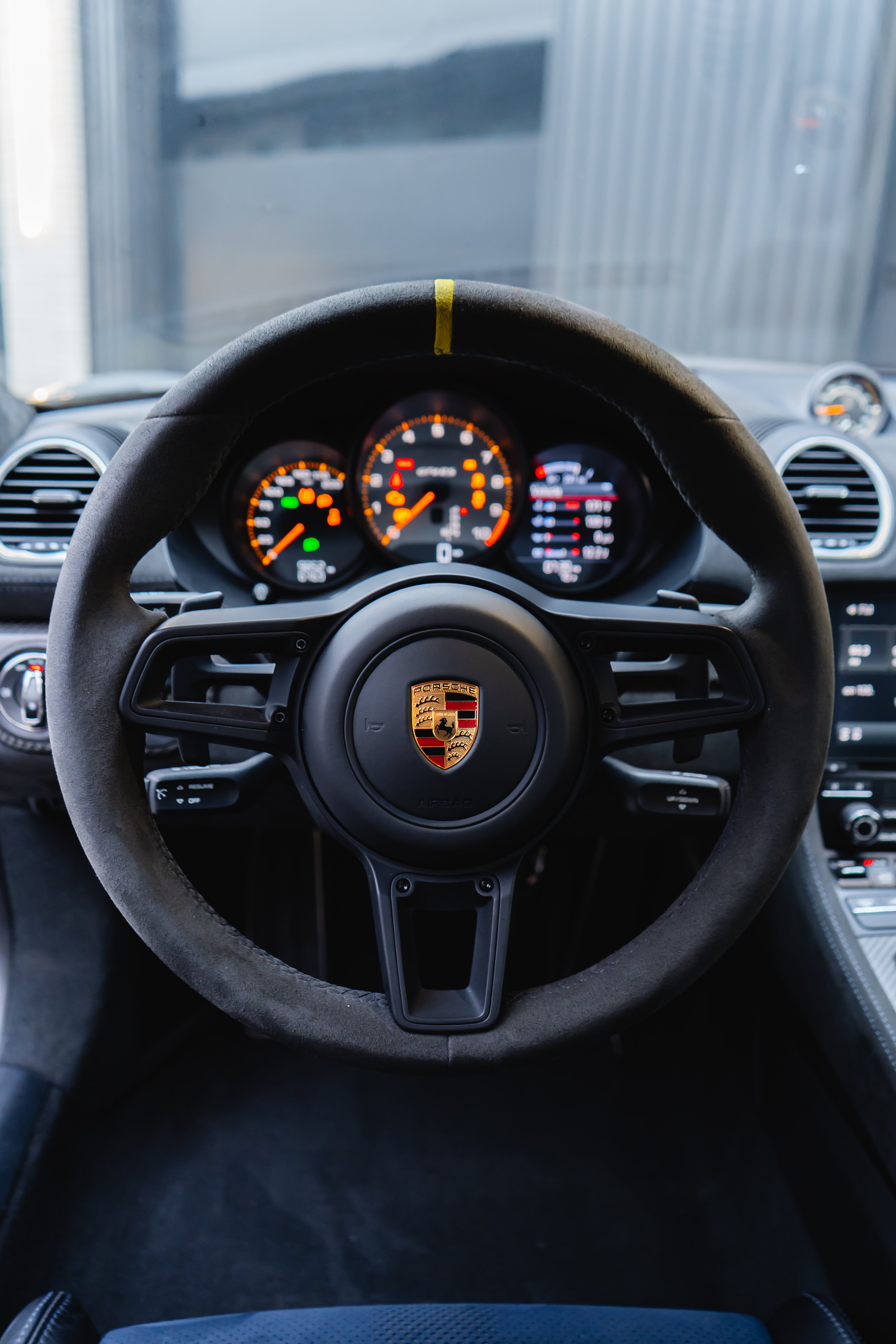 Alcantara steering wheel with yellow center stripe and illuminated gauges